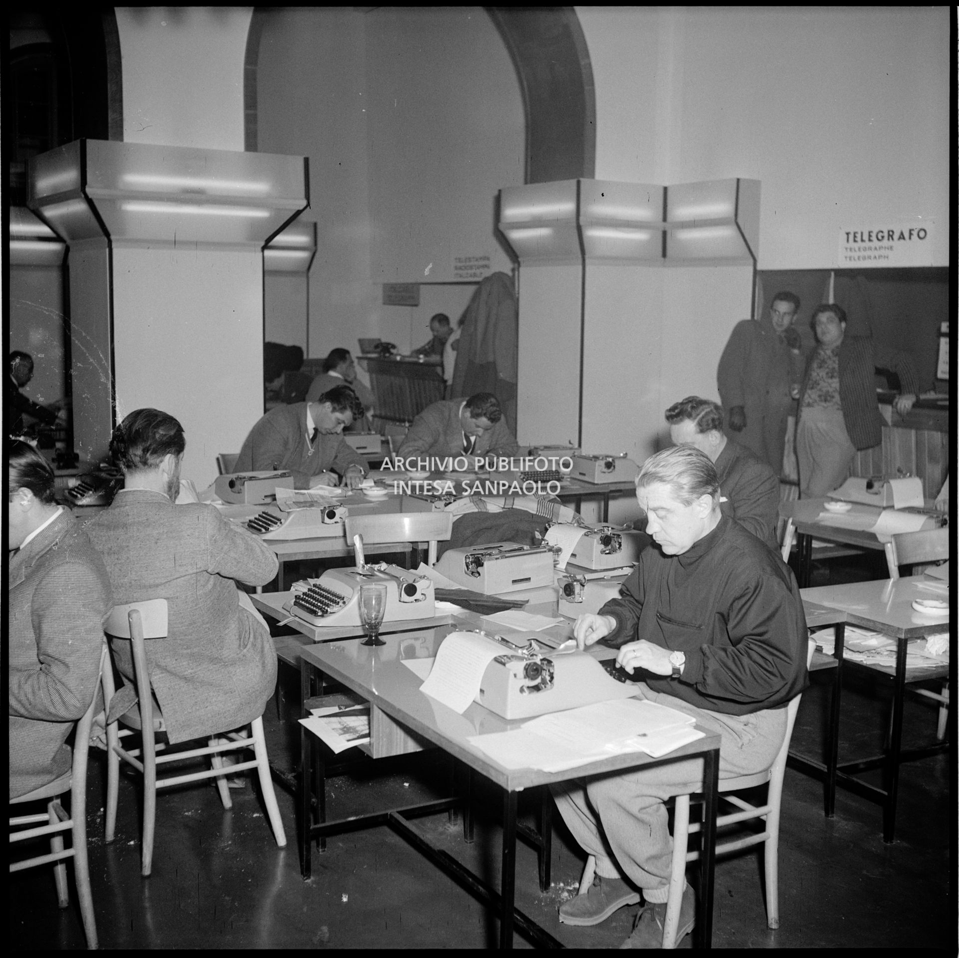 Giornalisti al lavoro nella sala stampa, attrezzata dalla Olivetti con macchine da scrivere delle principali lingue del mondo, presso l'albergo Savoia a Cortina d'Ampezzo