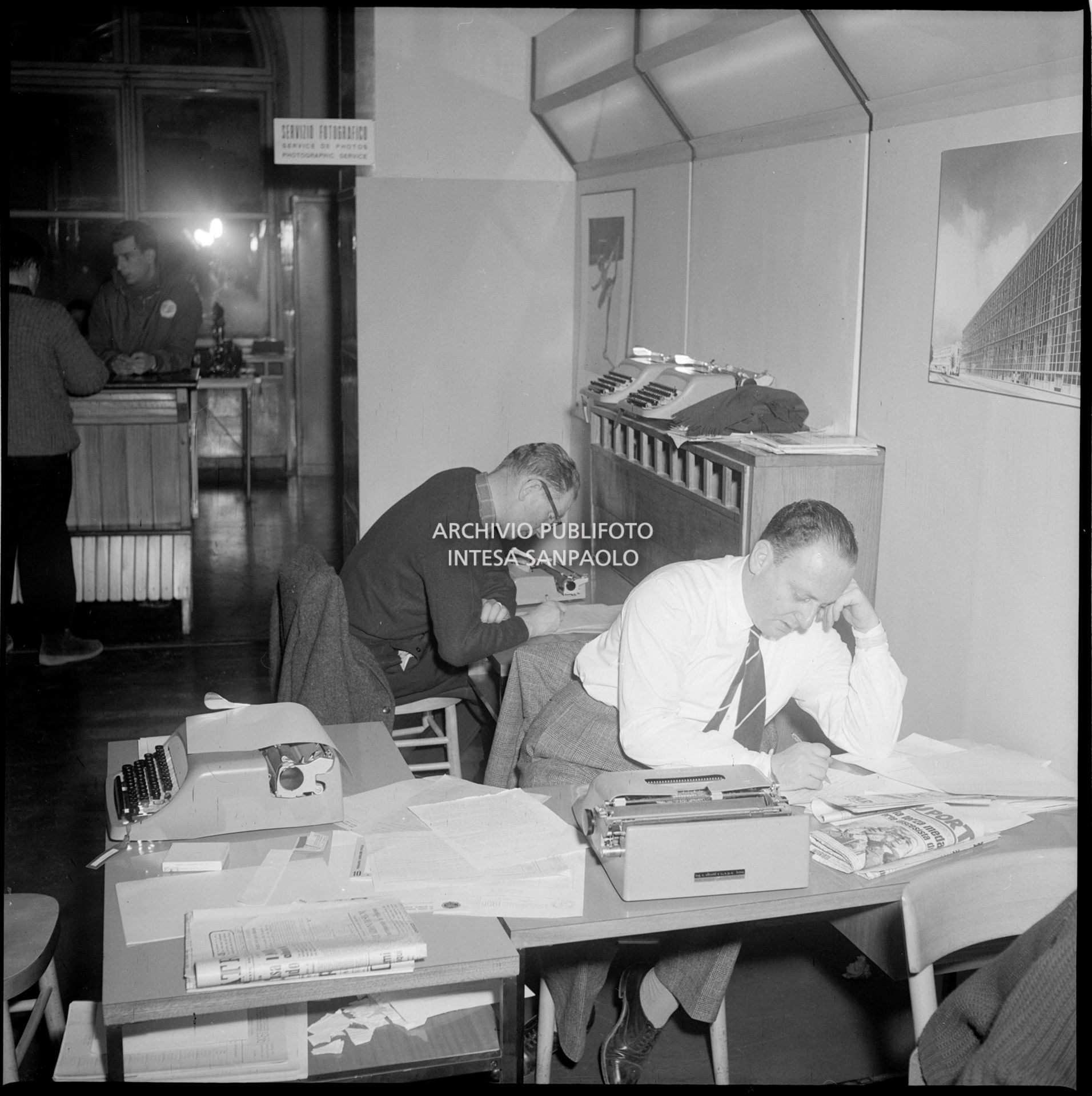 Giornalisti nella sala stampa, attrezzata dalla Olivetti con macchine da scrivere delle principali lingue del mondo, presso l'albergo Savoia a Cortina d'Ampezzo