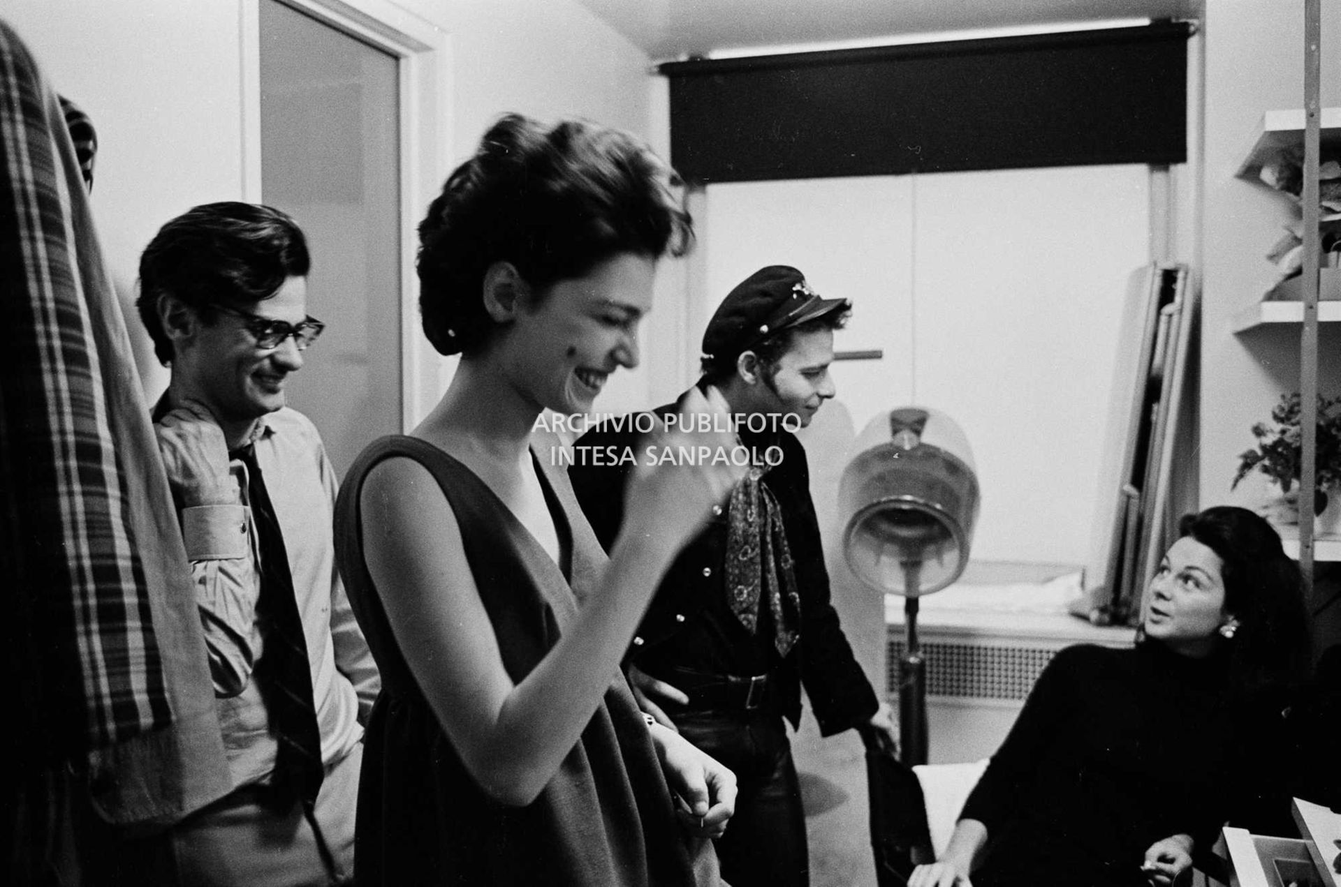 Benedetta Barzini ride in camerino; alle sue spalle Richard Avedon, sullo sfondo due collaboratori