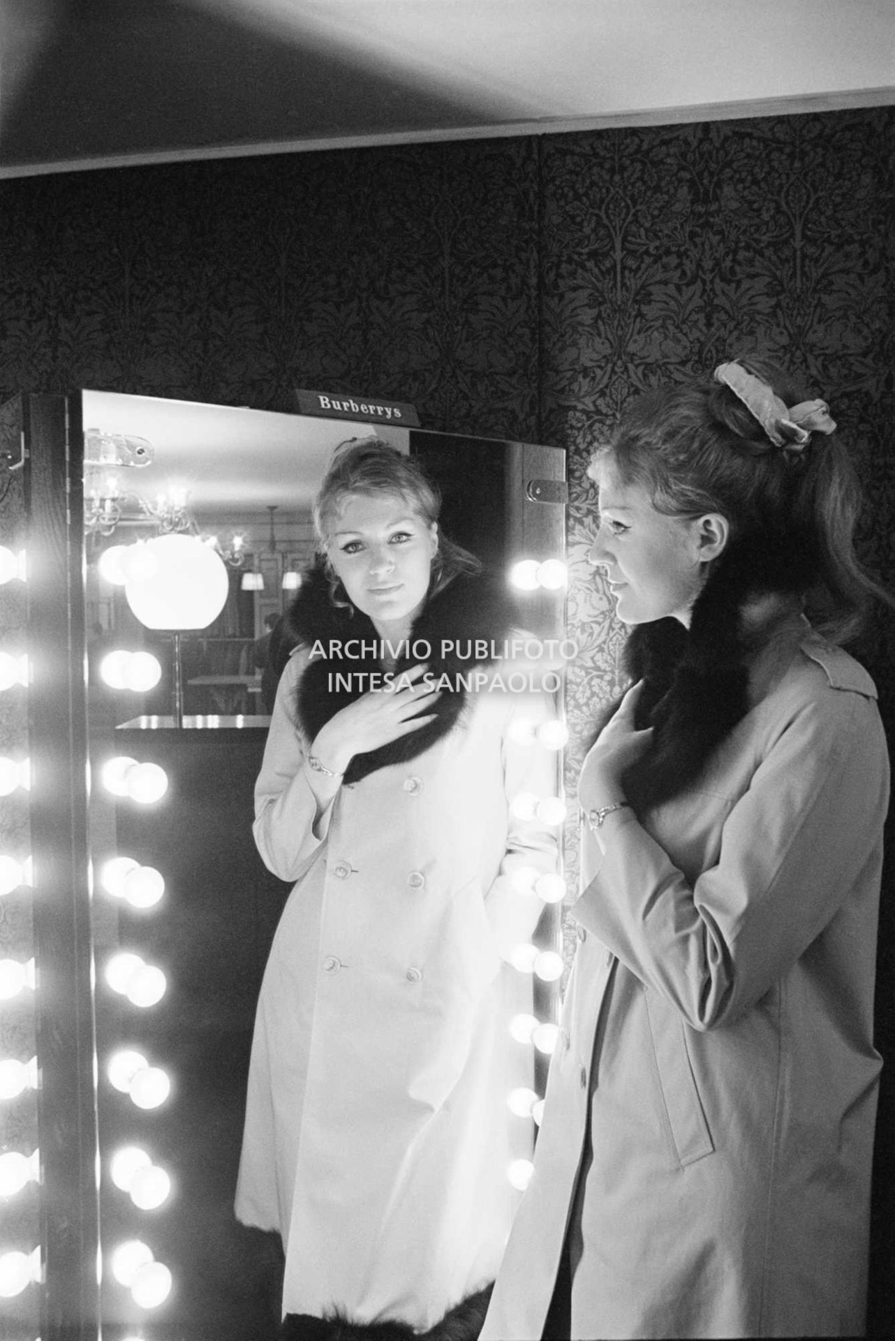 Anna German, con indosso un trench con l'interno in pelliccia, si specchia al negozio Burberrys'