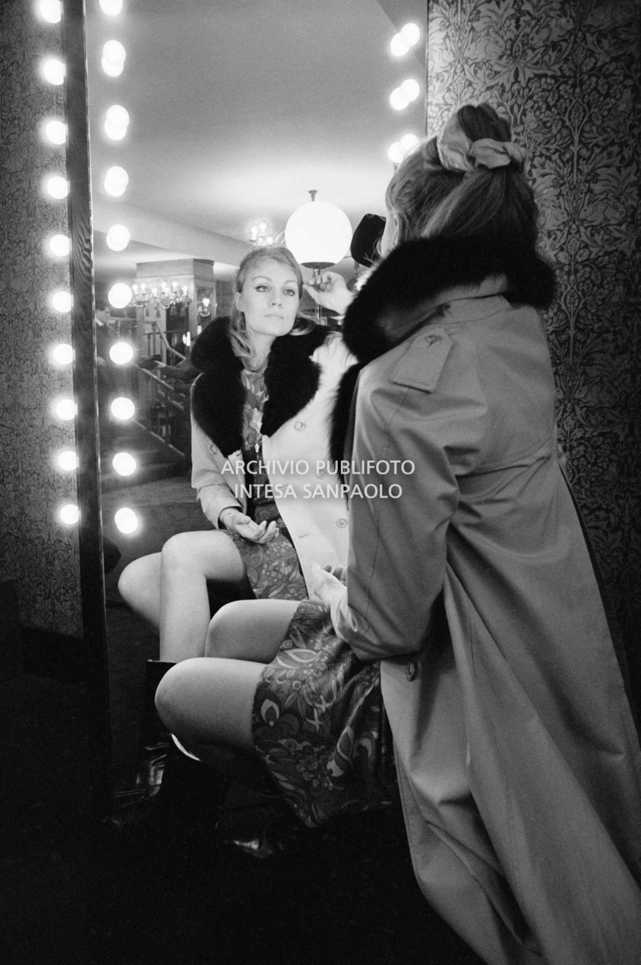 Anna German, con indosso un trench con l'interno in pelliccia, si specchia al negozio Burberrys'