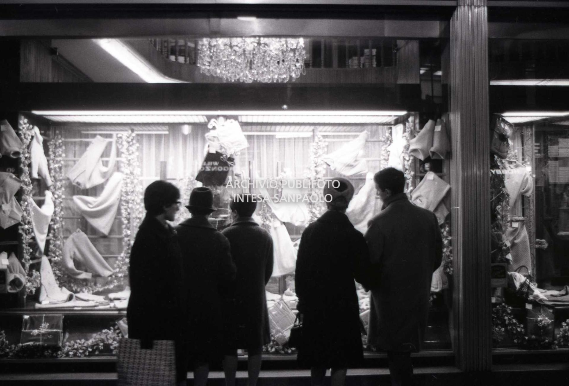 Passanti davanti alle vetrine dei negozi, a Milano, nei giorni precedenti il Natale