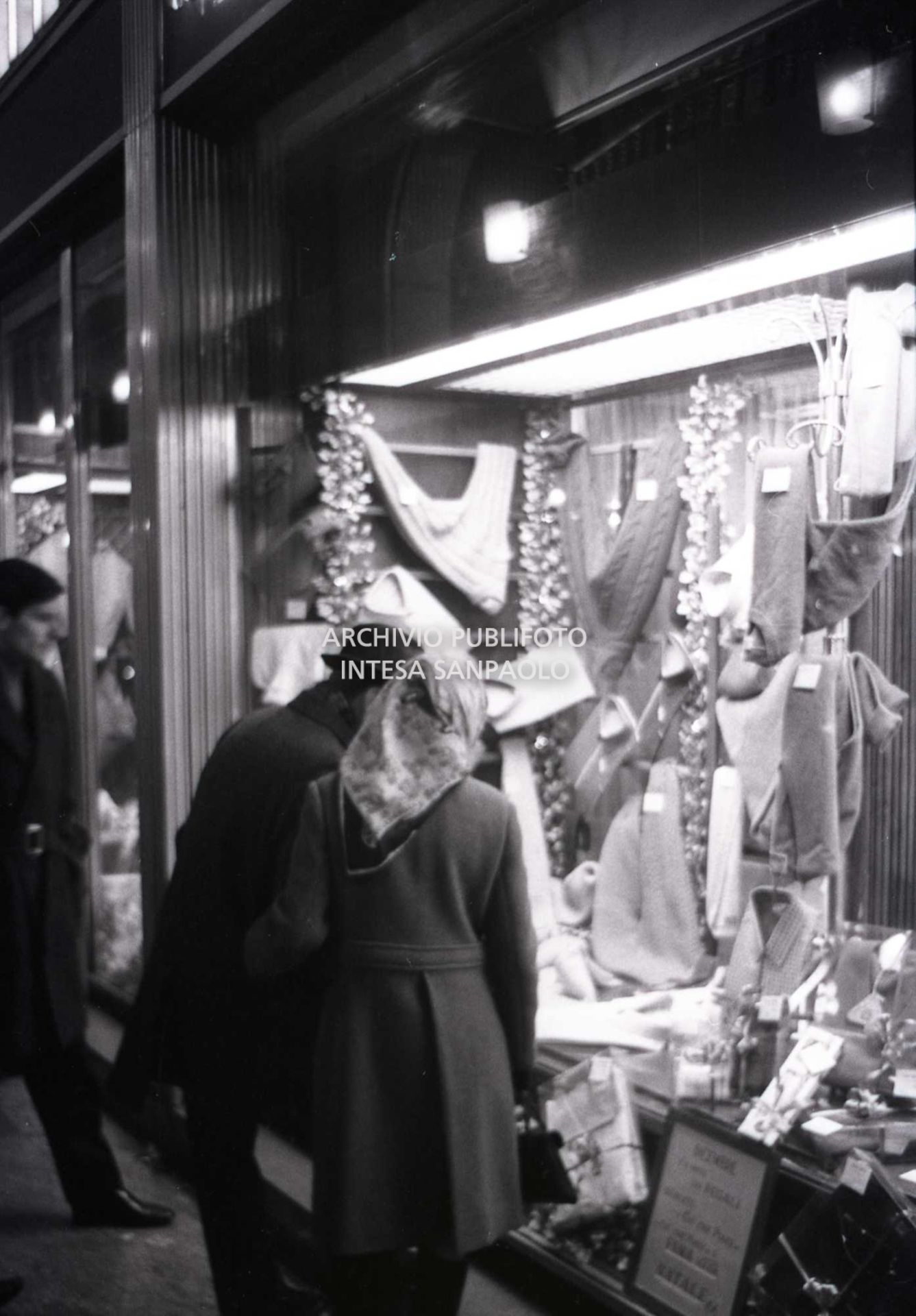 Passanti davanti alle vetrine dei negozi, a Milano, nei giorni precedenti il Natale