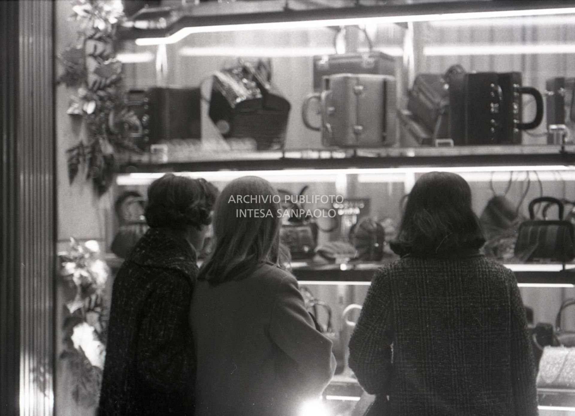 Passanti davanti alle vetrine dei negozi, a Milano, nei giorni precedenti il Natale