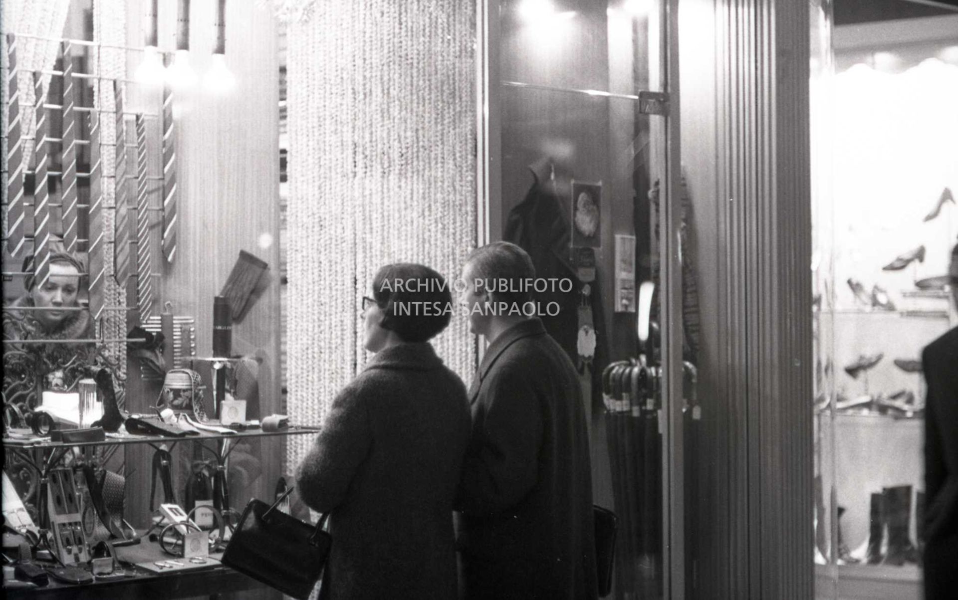 Passanti davanti alle vetrine dei negozi, a Milano, nei giorni precedenti il Natale