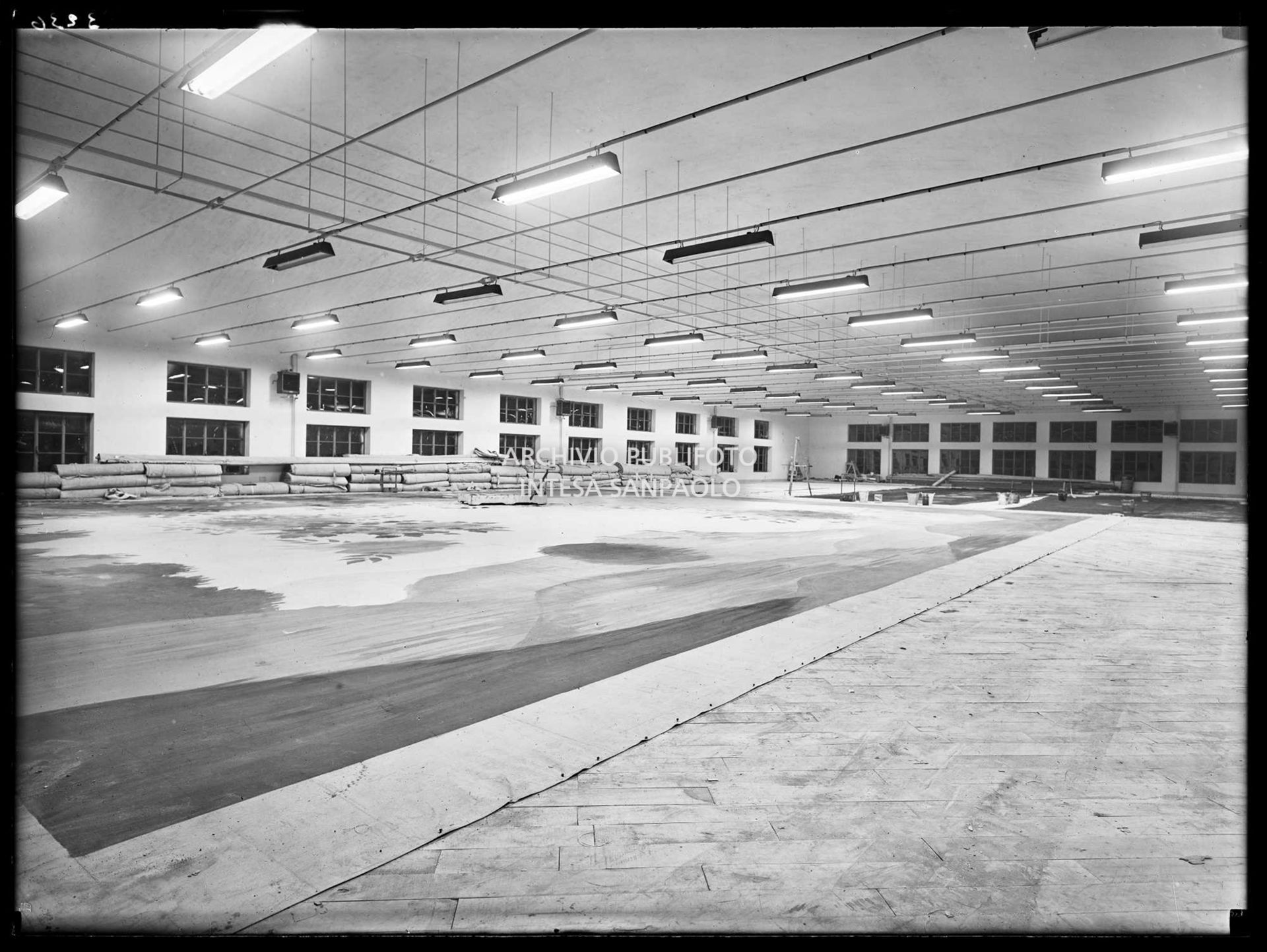Veduta di un laboratorio della sezione scenografia del Teatro alla Scala di Milano. Addossati ai muri materiali di lavoro, per terra un fondale in lavorazione