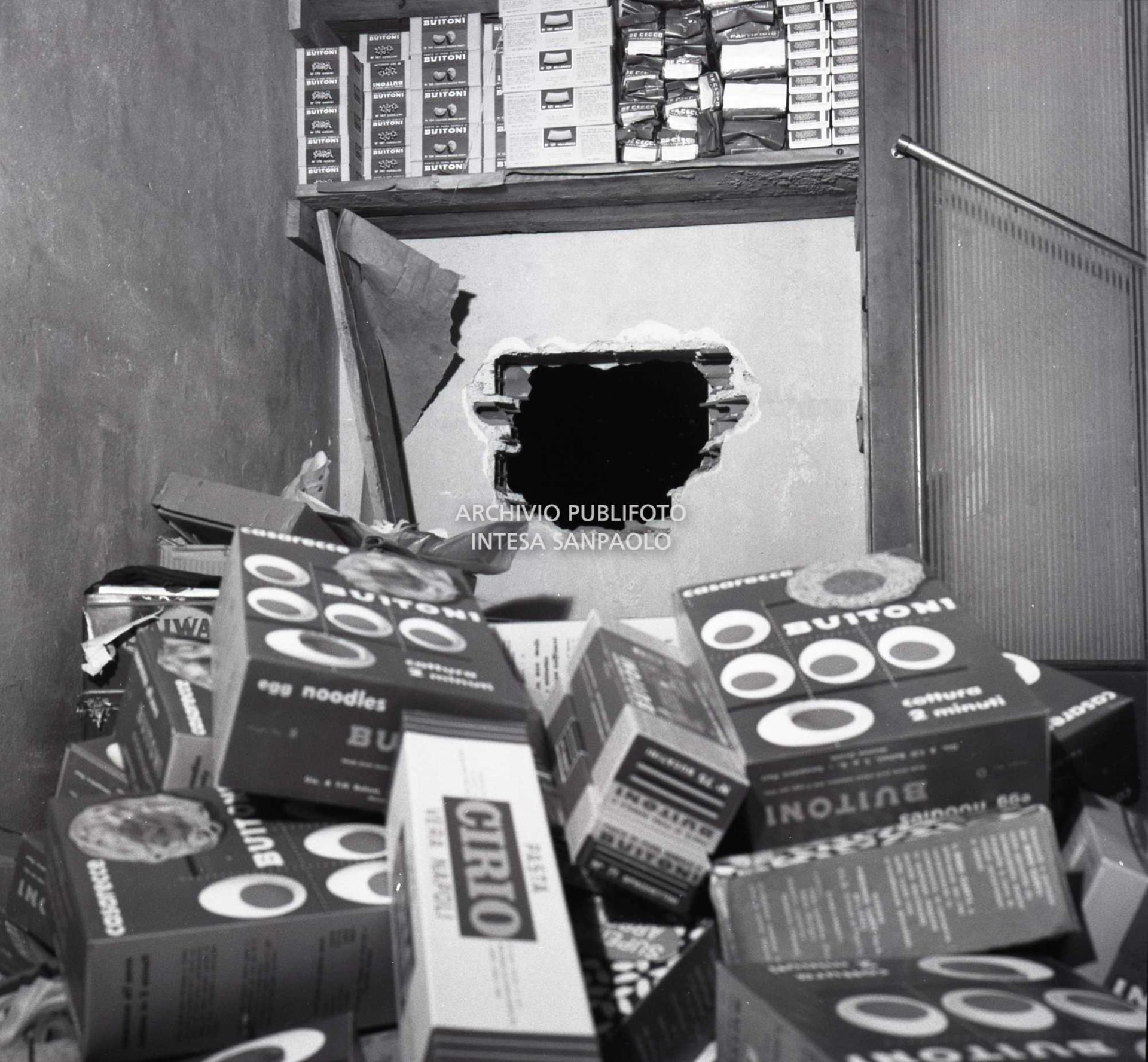 Il buco nel muro della panetteria, adiacente alla gioielleria, dal quale i rapinatori sono entrati nel negozio per poi introdursi nell'oreficeria; in primo piano varie scatole di prodotti alimentari messi a soqquadro