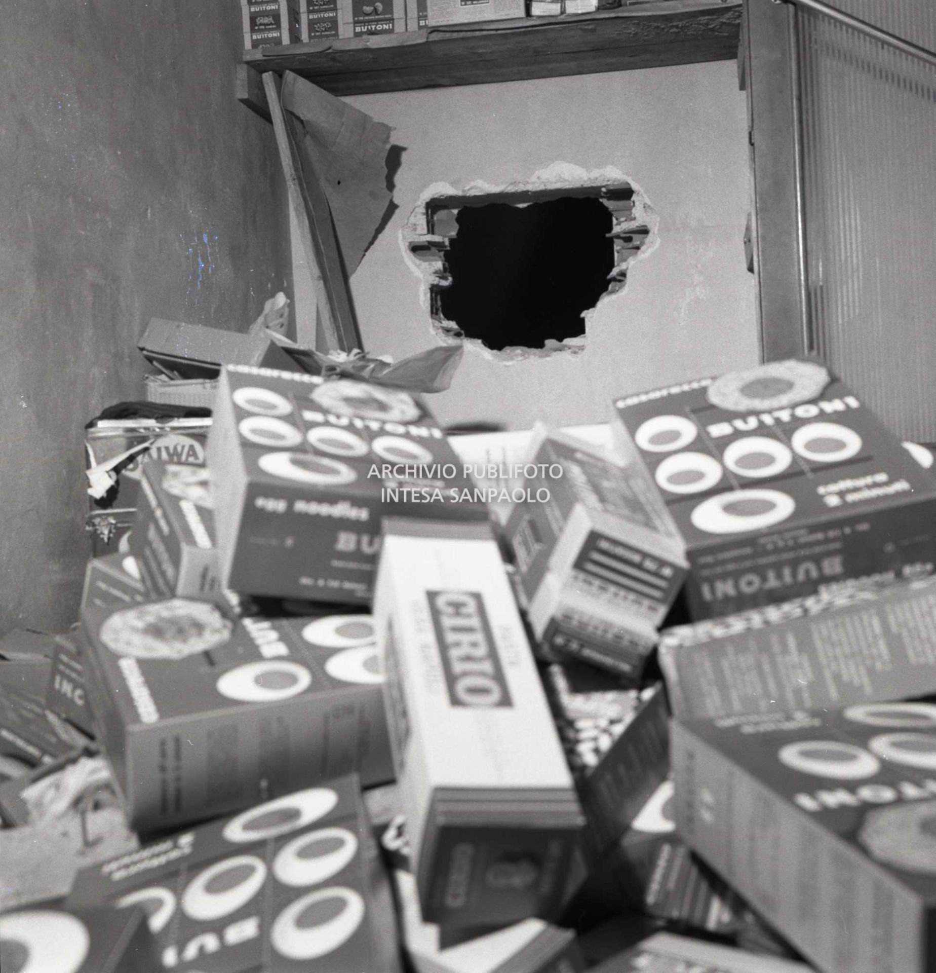 Il buco nel muro della panetteria, adiacente alla gioielleria, dal quale i rapinatori sono entrati nel negozio per poi introdursi nell'oreficeria; in primo piano varie scatole di prodotti alimentari messi a soqquadro