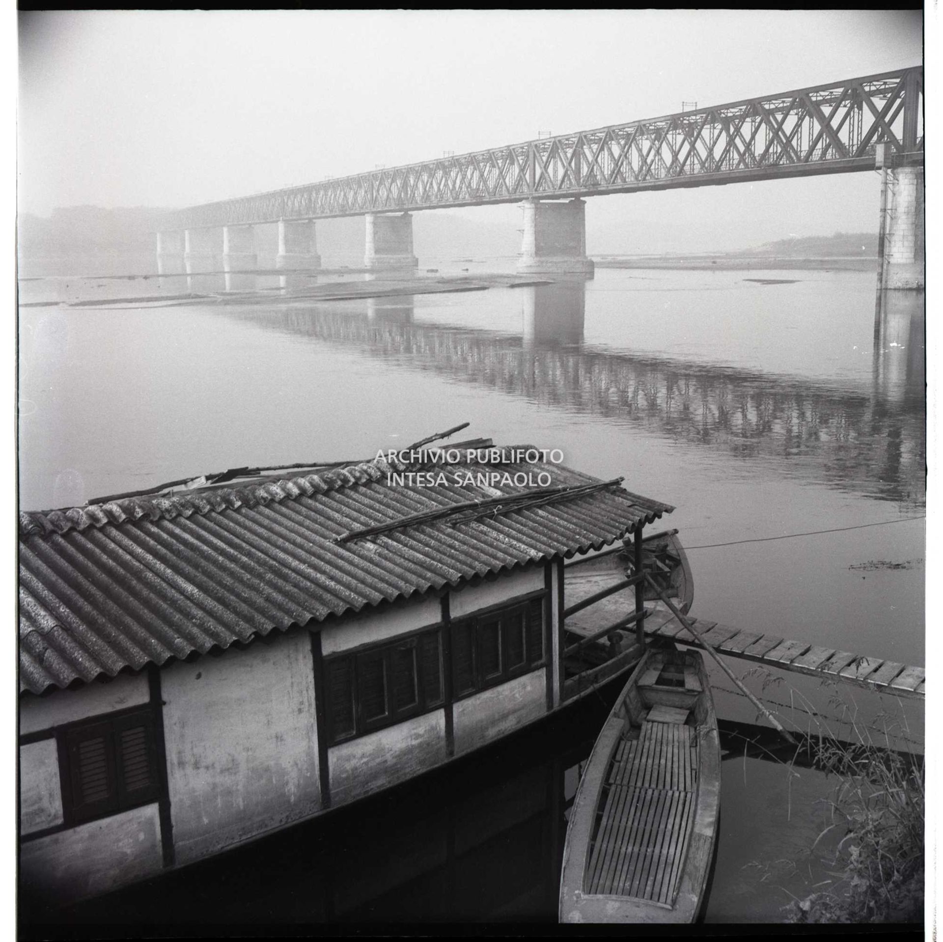 Scorcio del ponte in ferro, detto della Becca, sul Po in secca; in primo piano un barcone e una piccola imbarcazione