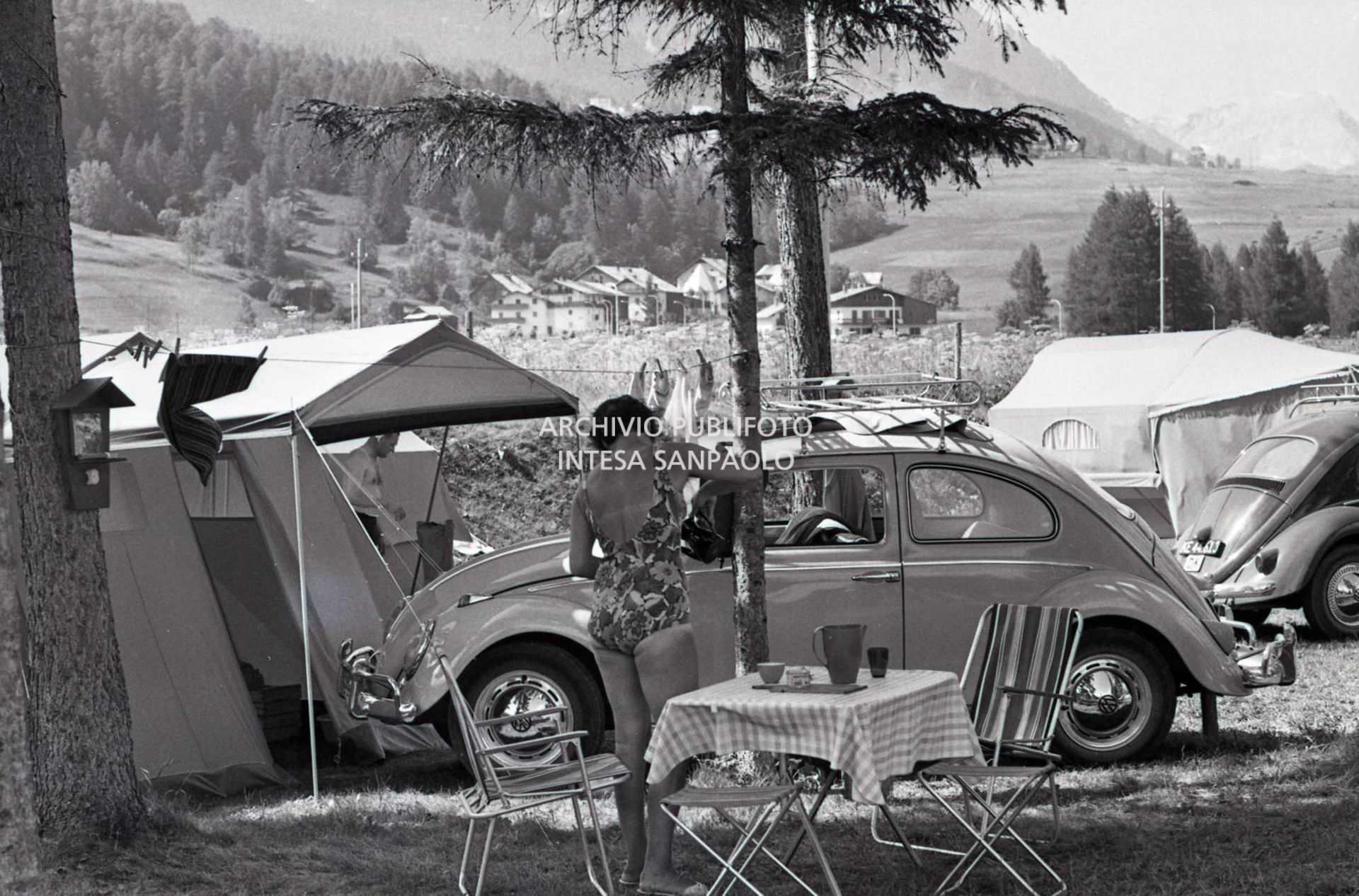 Turista in campeggio a Cortina d'Ampezzo tra tende a casetta e due Volkswagen Maggiolino