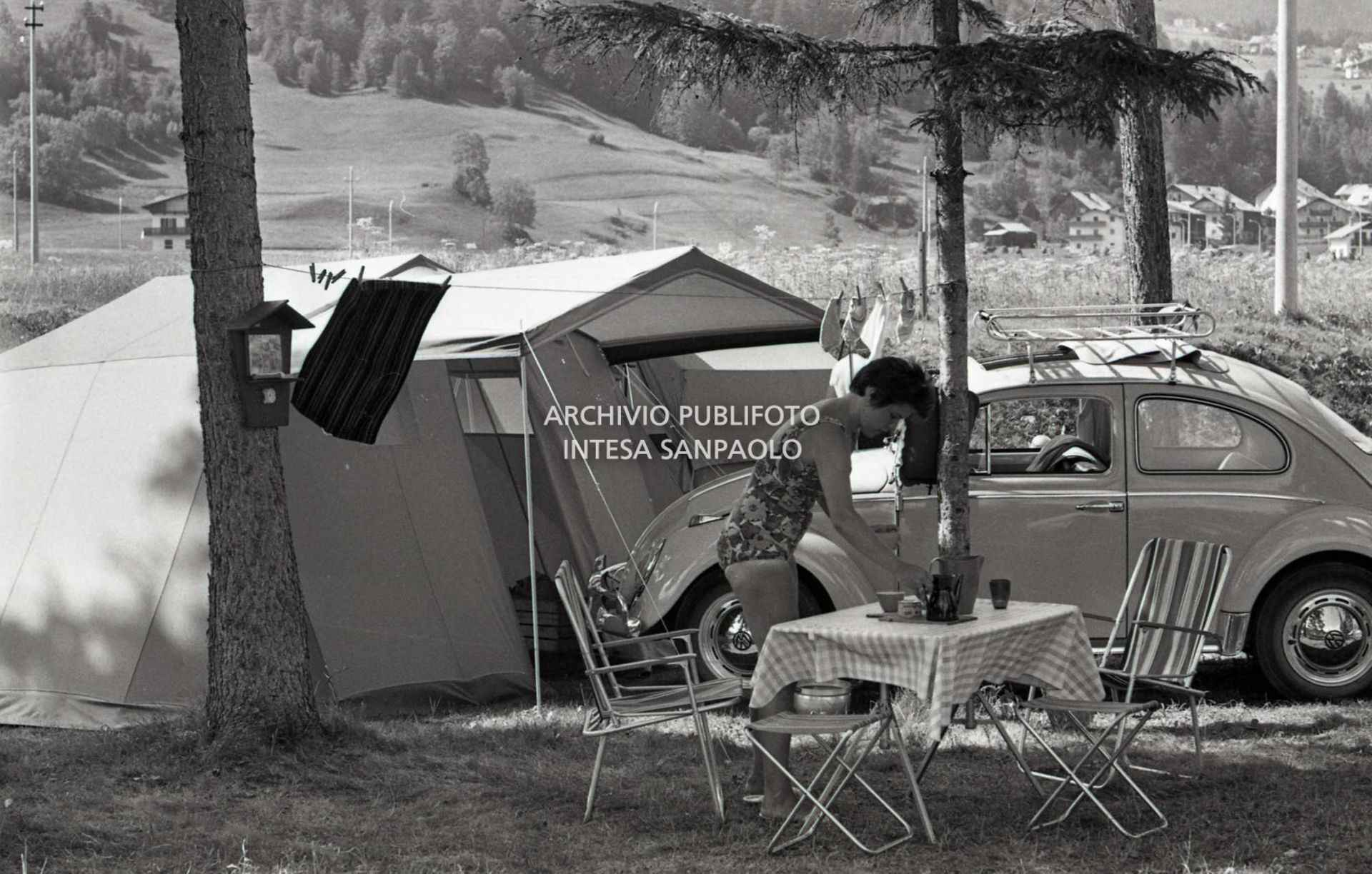 Turista in campeggio a Cortina d'Ampezzo tra tende a casetta e una Volkswagen Maggiolino