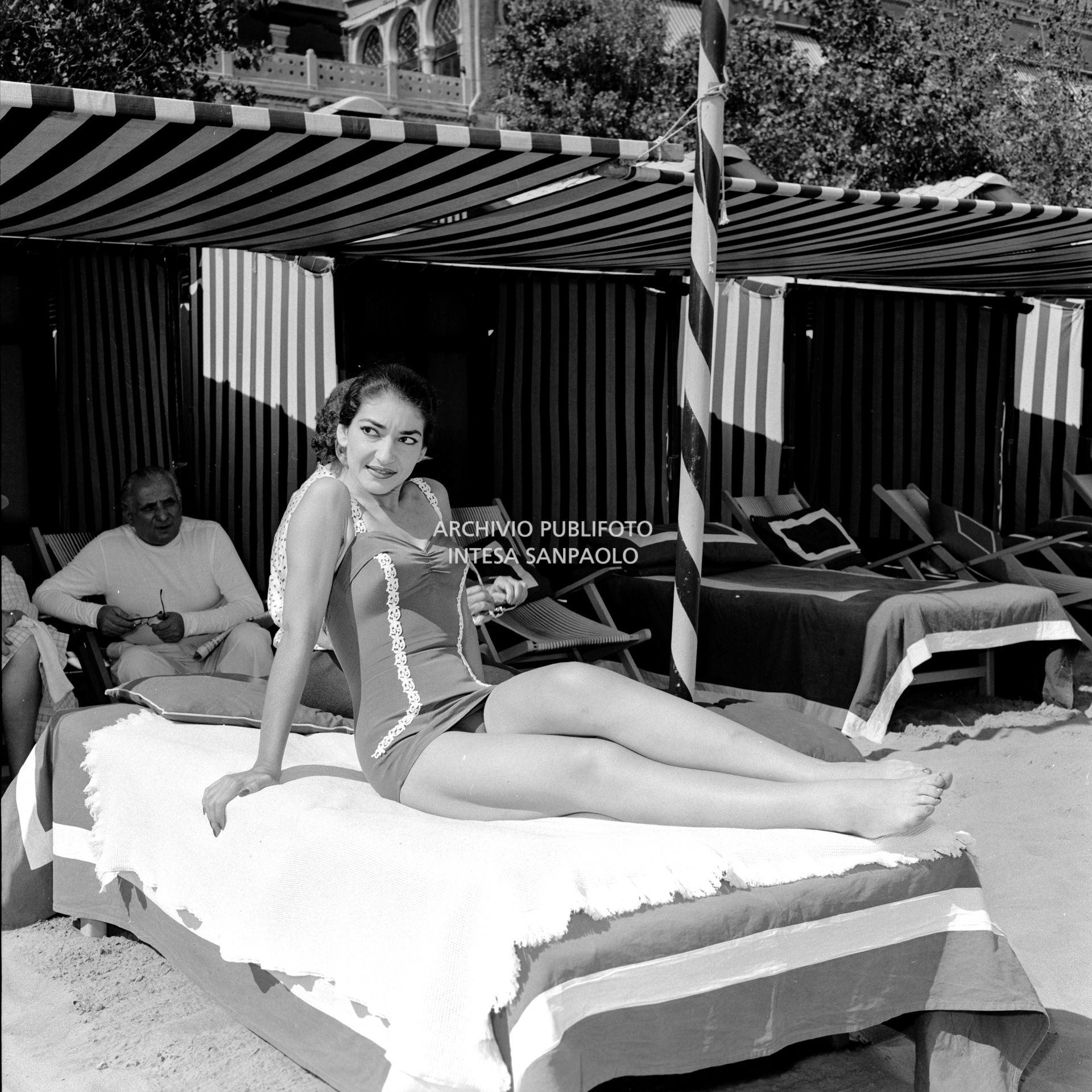La soprano Maria Callas in costume da bagno sdraiata su un lettino al Lido di Venezia