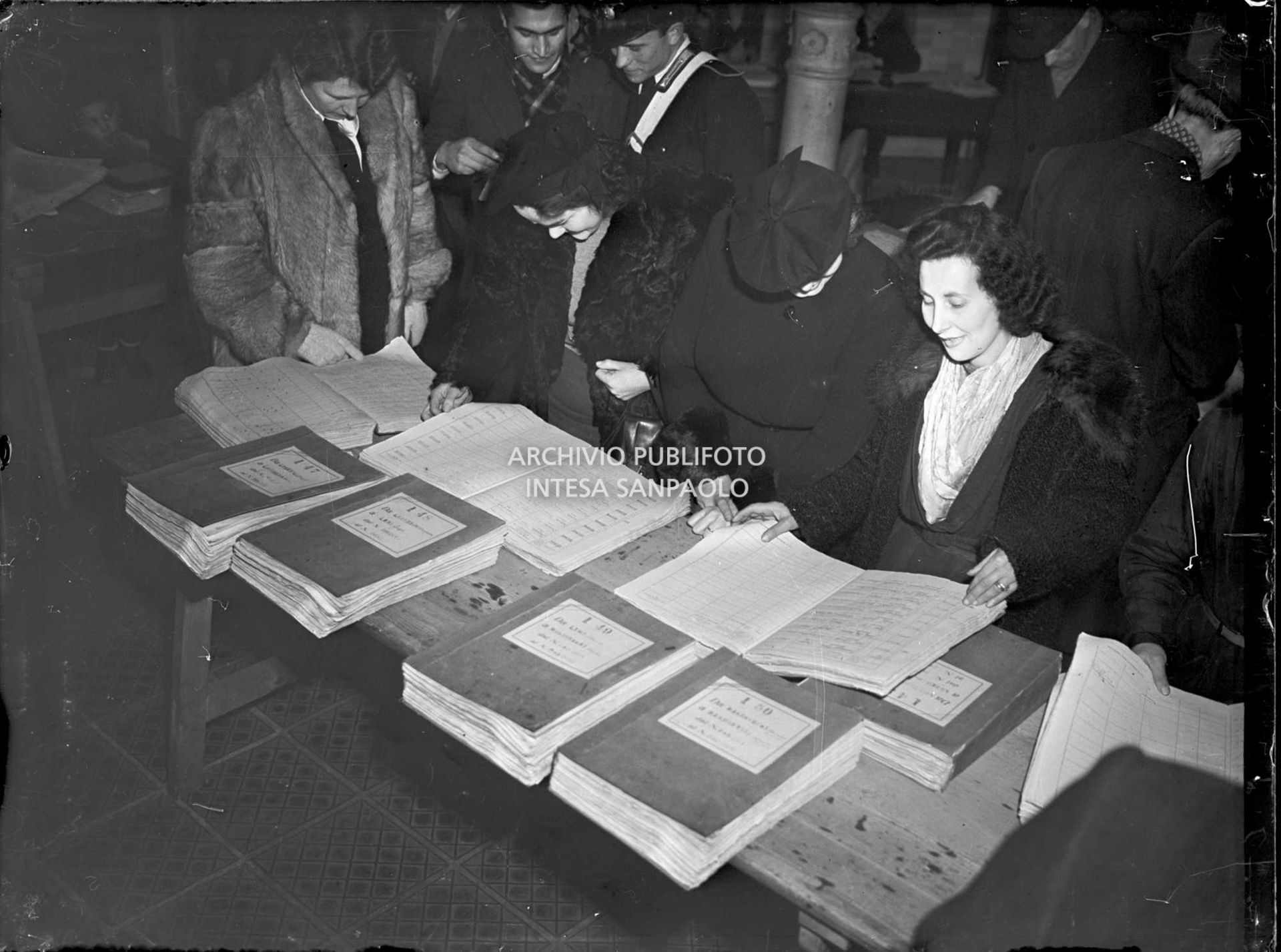 Due donne consultano i registri con gli iscritti ai seggi elettorali in vista delle elezioni amministrative del 7 aprile 1946