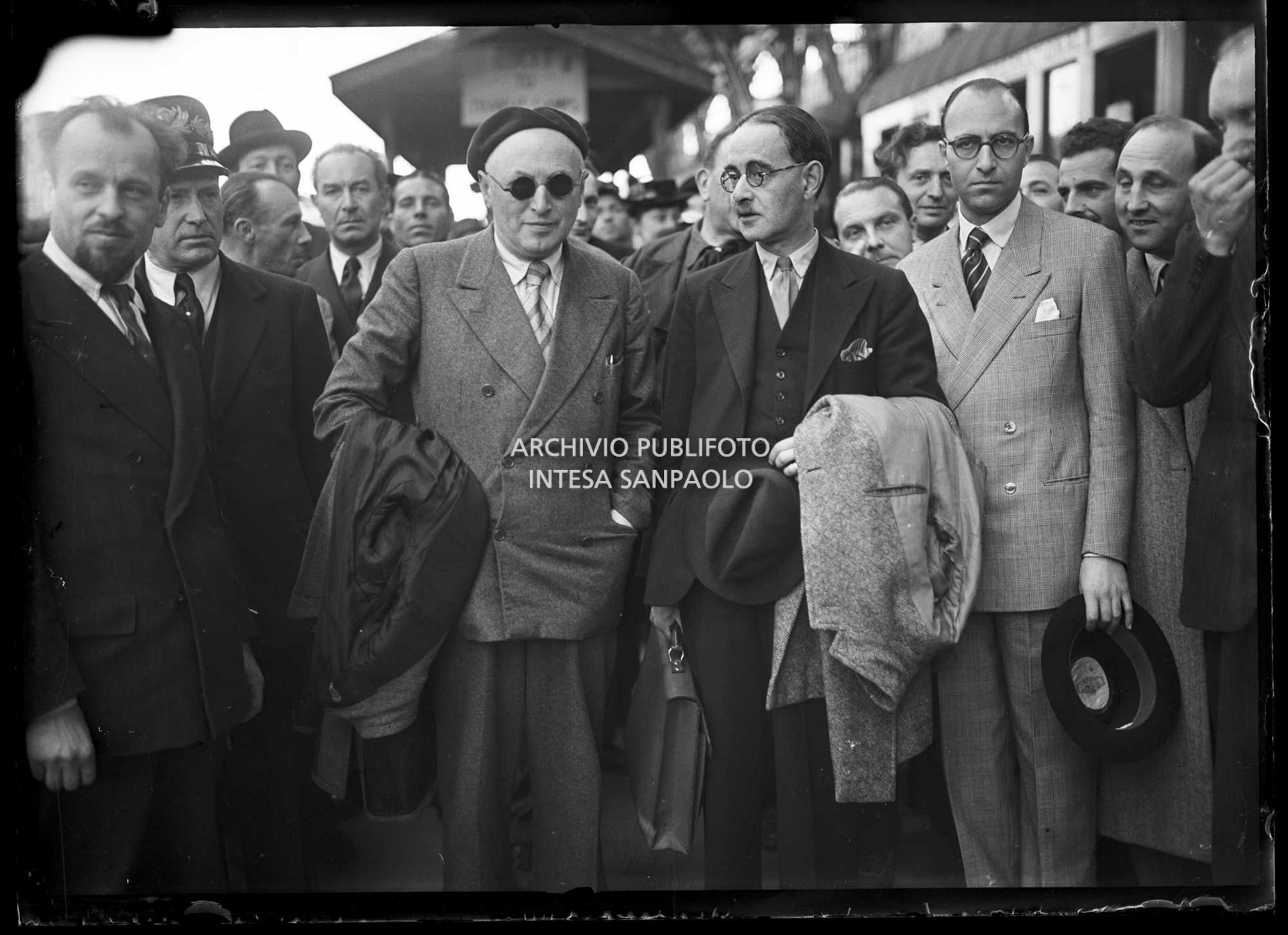 Harold Laski (con il soprabito sul braccio), presidente del Partito laburista inglese, appena arrivato a Milano, accolto da Pietro Nenni (a sinistra con gli occhiali da sole)