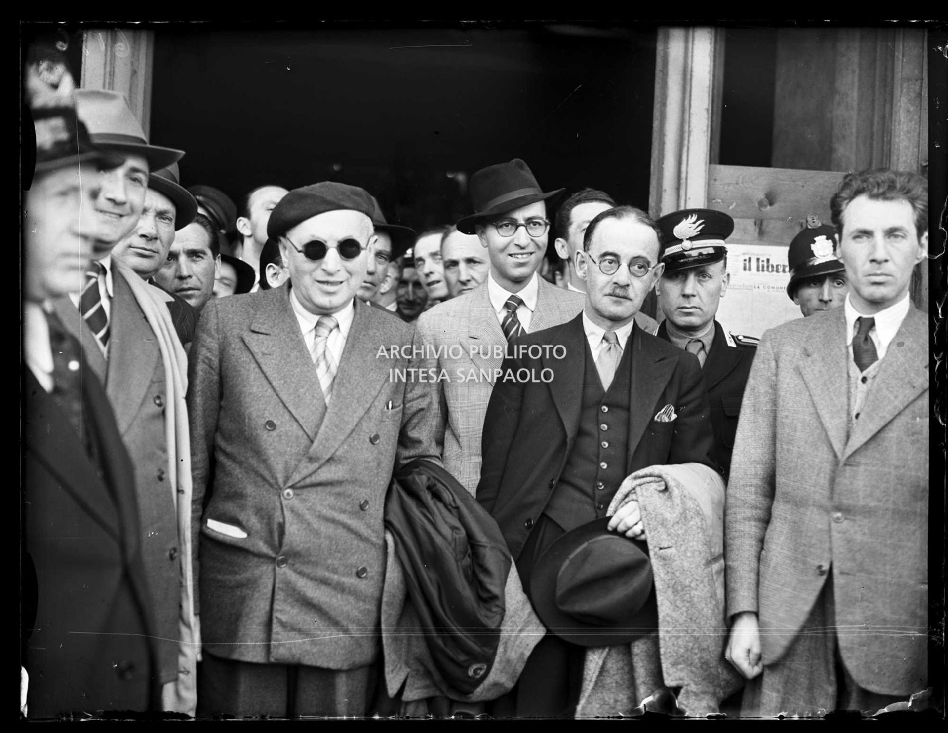Harold Laski (con il soprabito sul braccio), presidente del Partito laburista inglese, appena arrivato a Milano, accolto da Pietro Nenni (al centro con gli occhiali da sole)