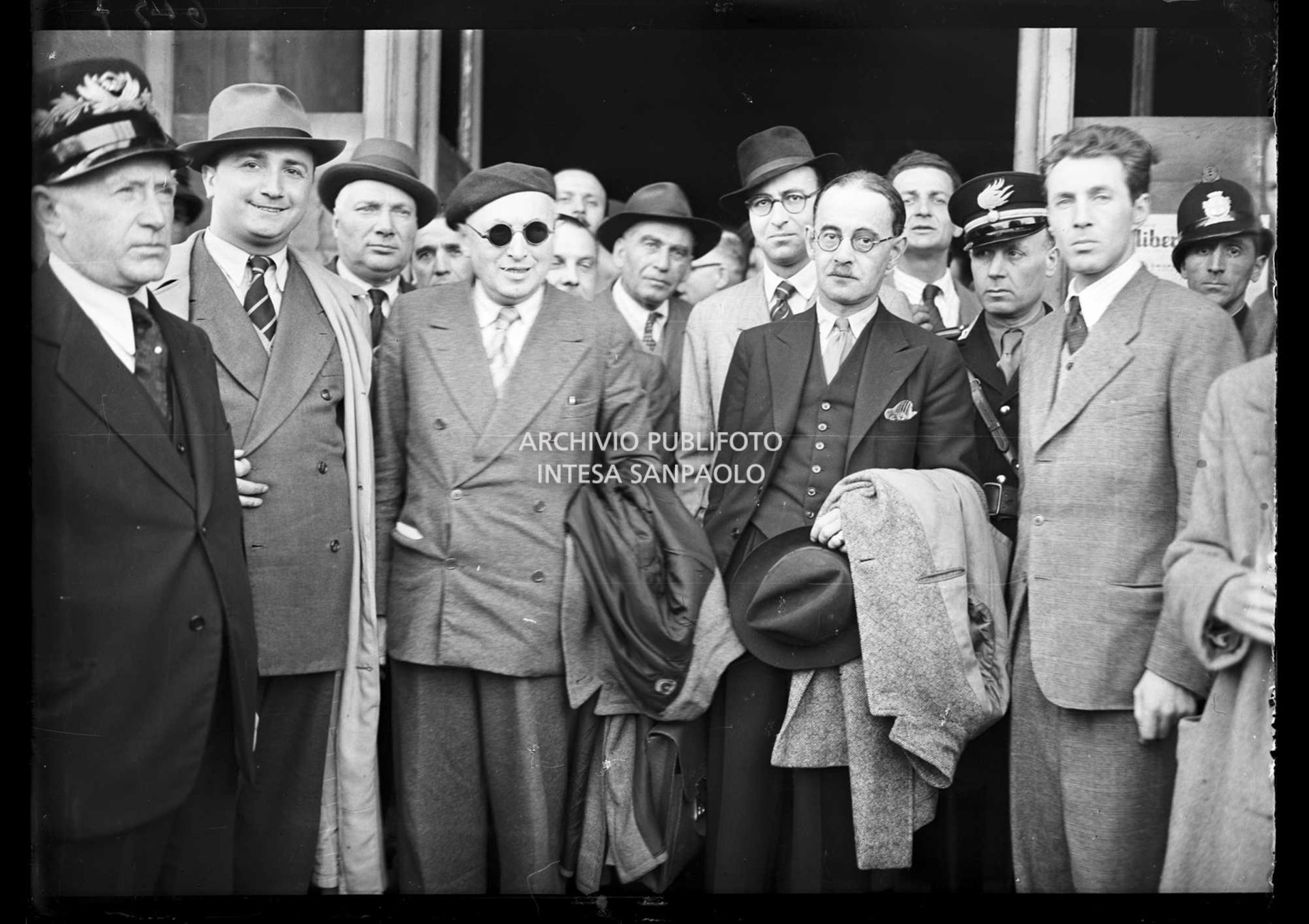 Harold Laski (con il soprabito sul braccio), presidente del Partito laburista inglese, appena arrivato a Milano, accolto da Pietro Nenni (al centro con gli occhiali da sole)