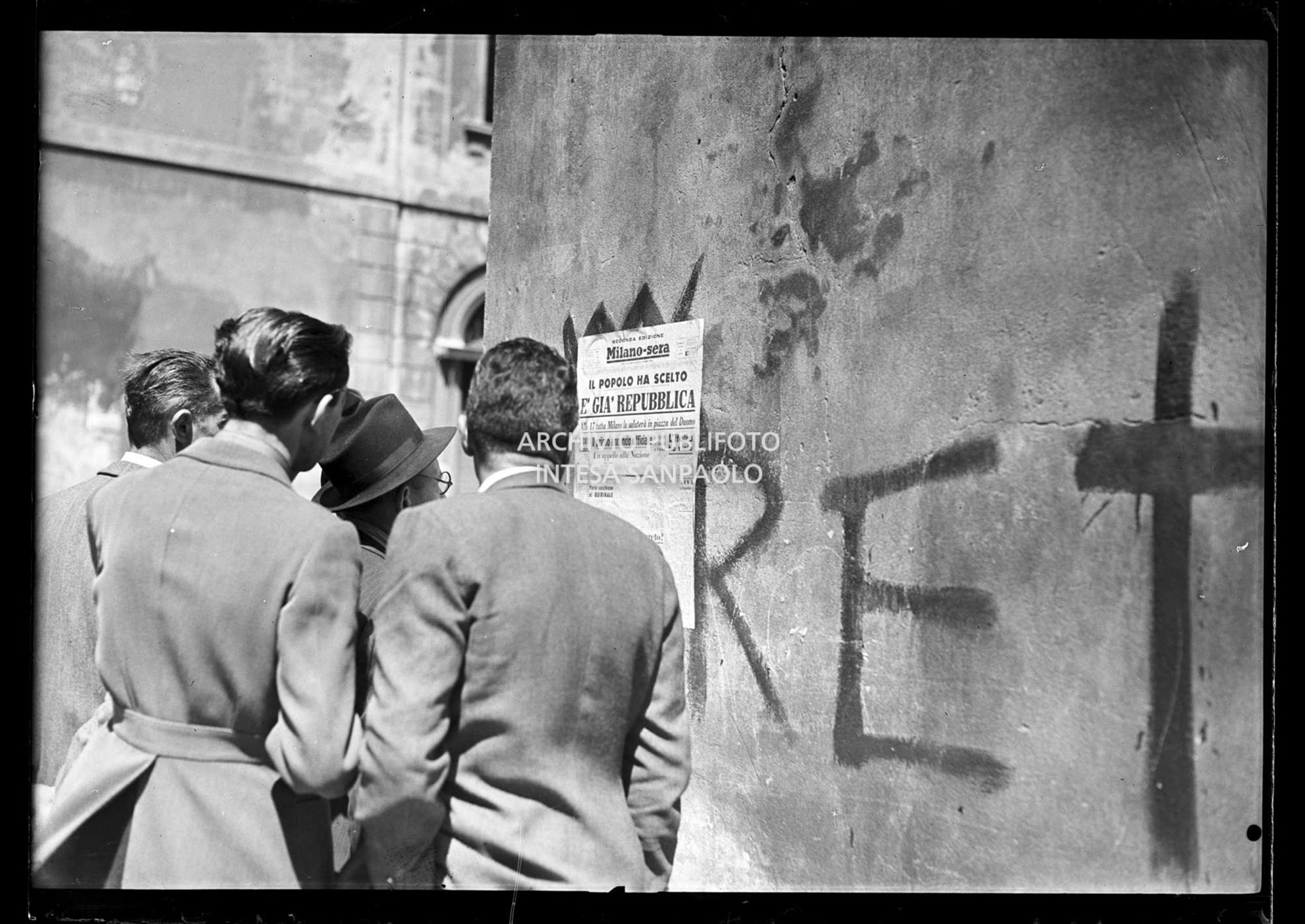 Passanti leggono il titolo della seconda edizione del quotidiano Milano-Sera, affisso a un muro, che titola: "Il popolo ha scelto. È già Repubblica"