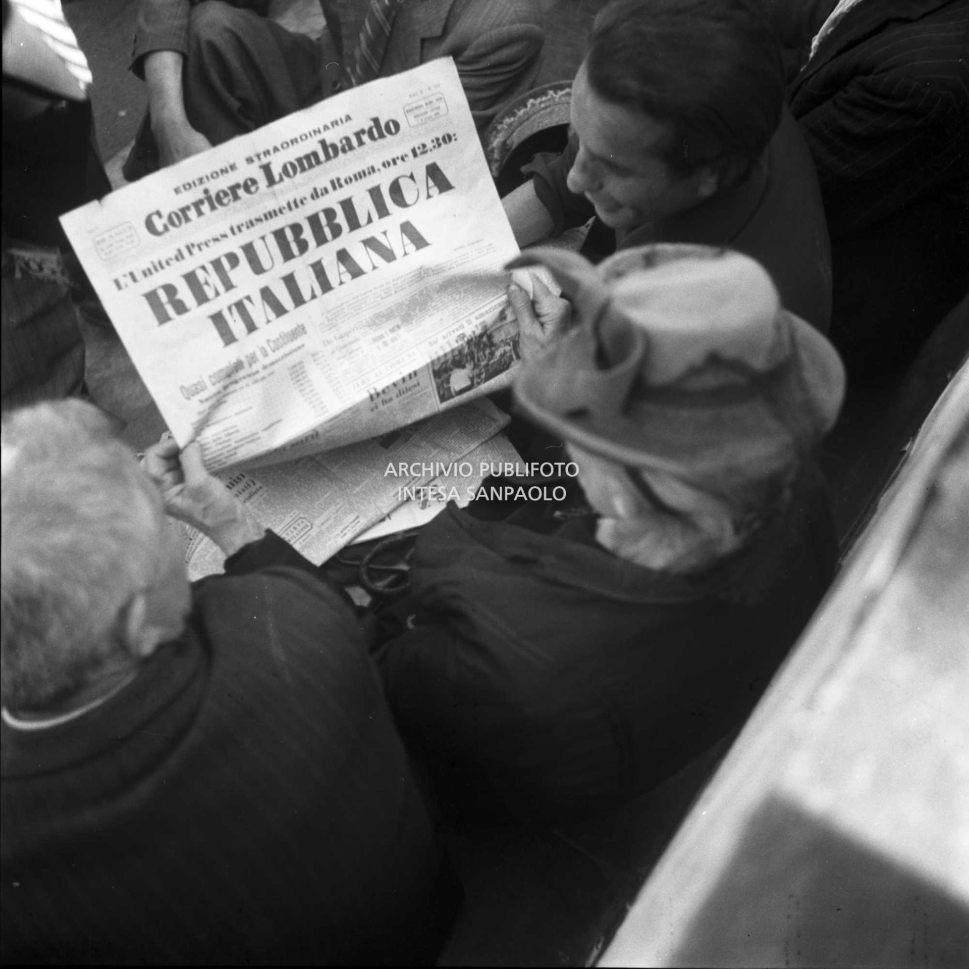 Una donna ripresa di spalle legge l'edizione straordinaria del Corriere Lombardo che titola, all'indomani del referendum, "L'United Press trasmette da Roma ore 12.30: Repubblica Italiana"