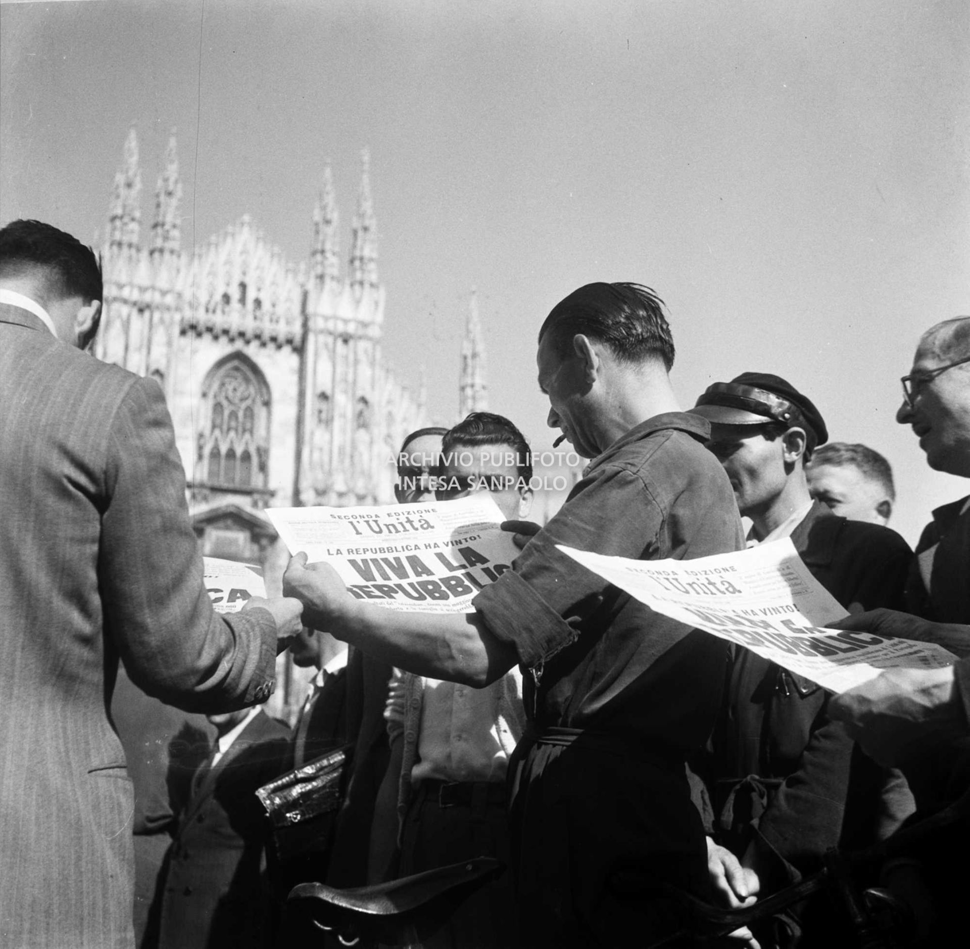 Uomini, in piazza del Duomo a Milano, leggono la seconda edizione del quotidiano l'Unità che titola: "La Repubblica ha vinto. Viva la Repubblica"