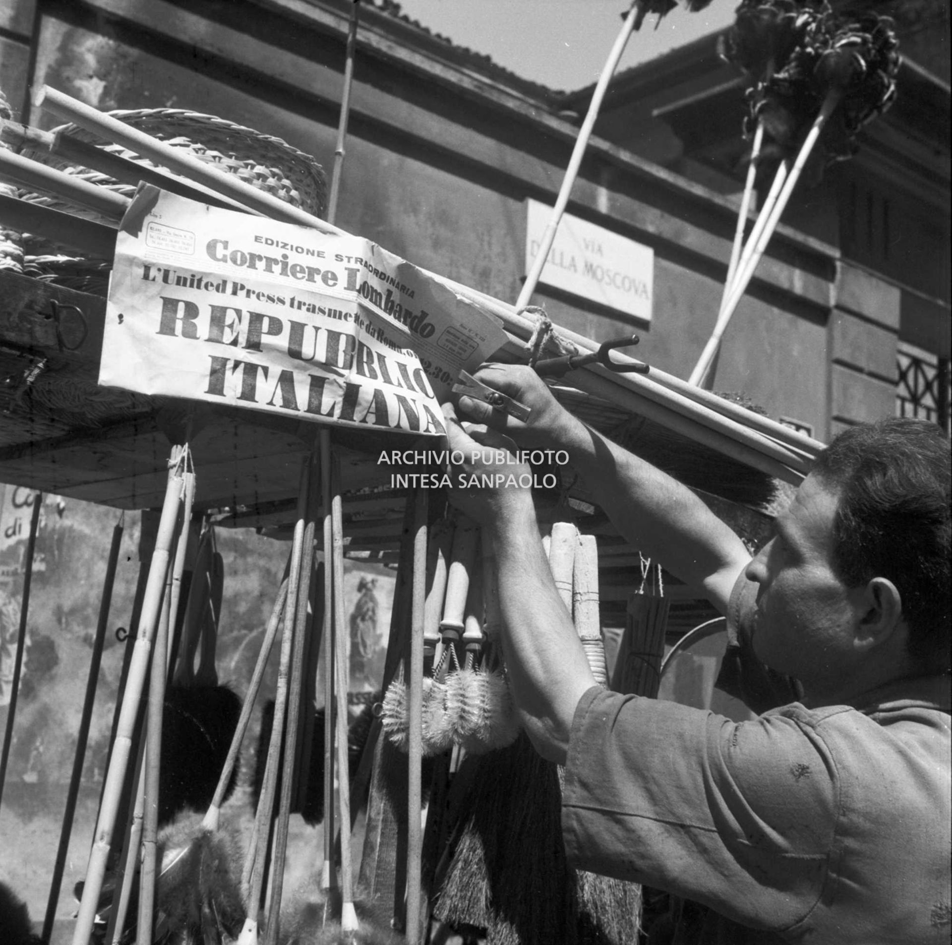 Un ambulante ha appeso alla sua bancarella, in via della Moscova a Milano, l'edizione straordinaria del Corriere Lombardo che titola, all'indomani del referendum, "L'United Press trasmette da Roma ore 12.30: Repubblica Italiana"