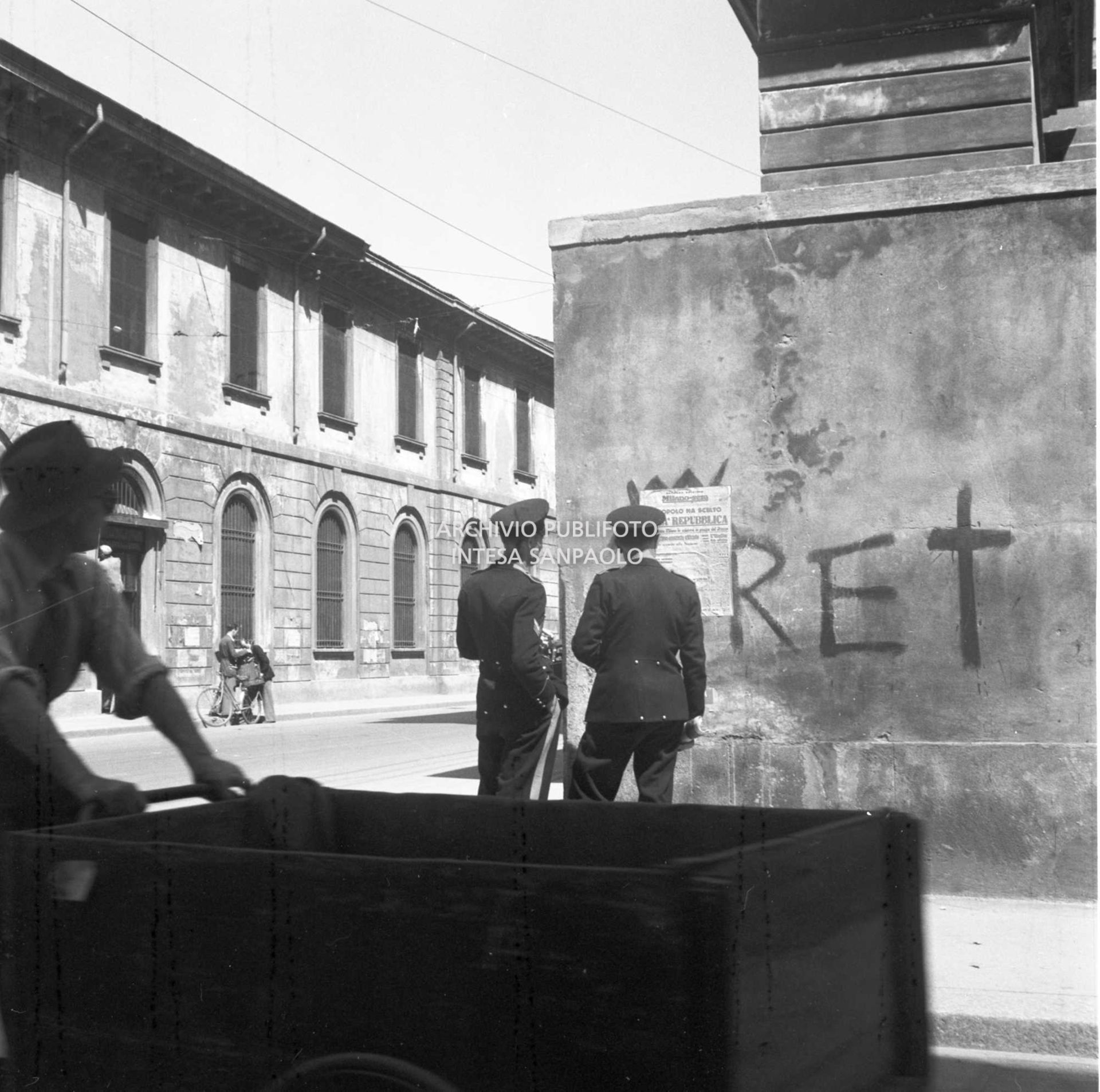 Due carabinieri per strada leggono la prima pagina della seconda edizione del quotidiano Milano-Sera, affissa a un muro, che titola: "Il popolo ha scelto. È già Repubblica"