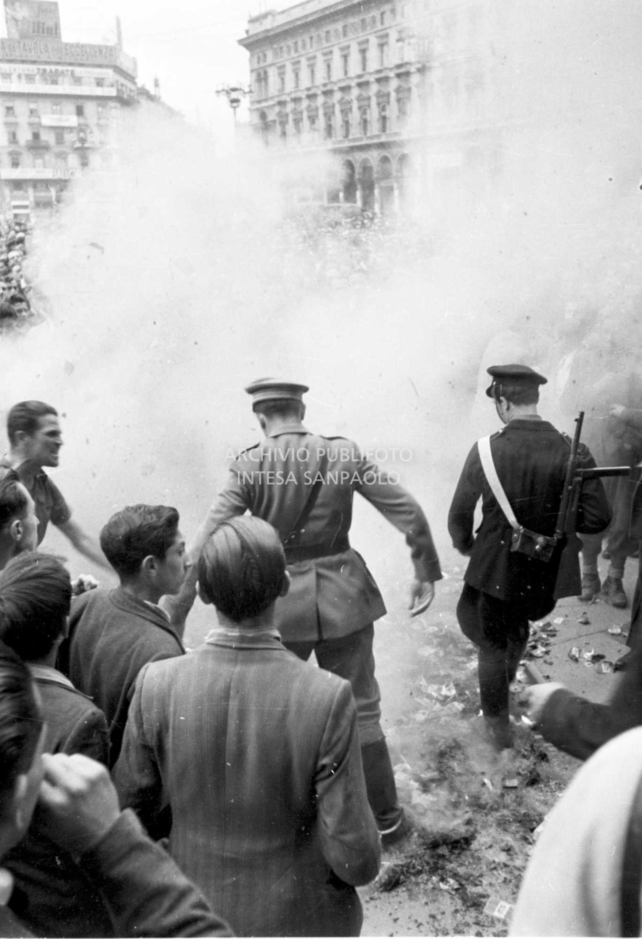 Forze dell'ordine calpestano volantini monarchici dati alle fiamme dalla folla accorsa a manifestare contro Umberto II in visita a Milano