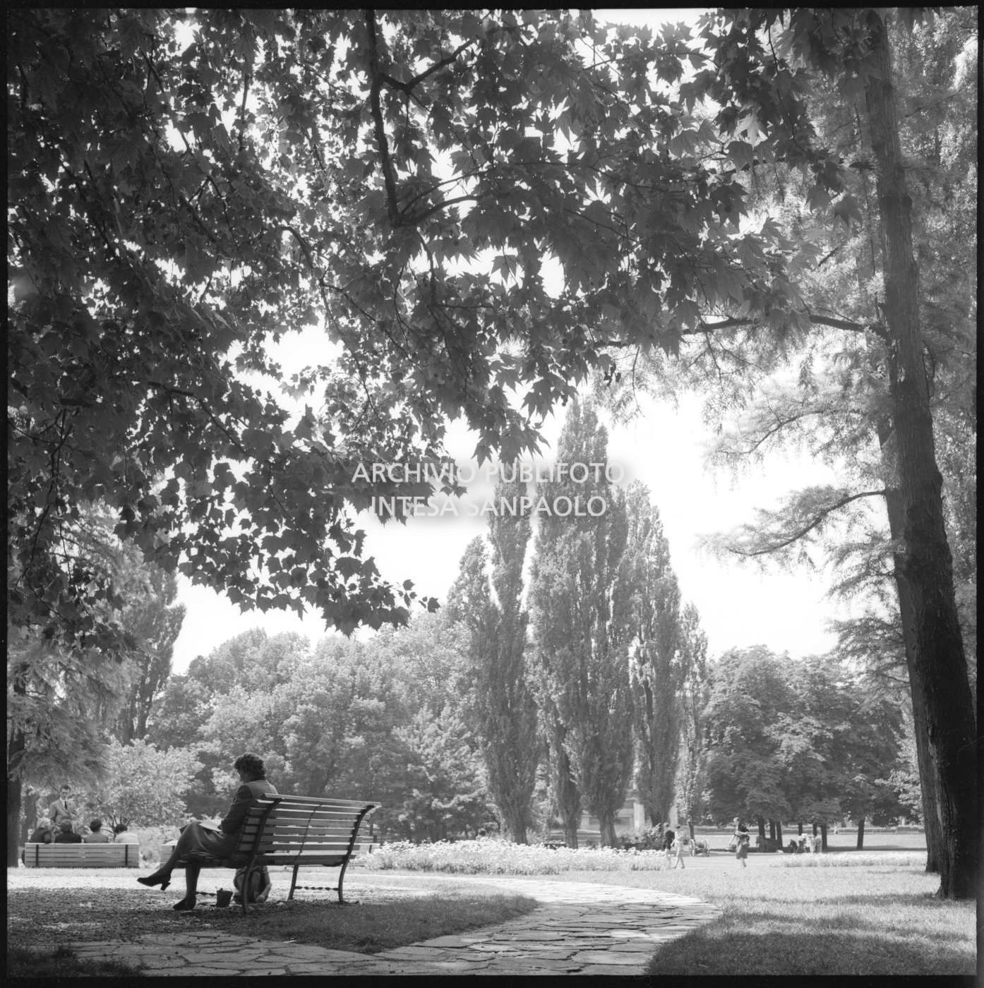Una donna seduta su una panchina ai Giardini pubblici di Milano