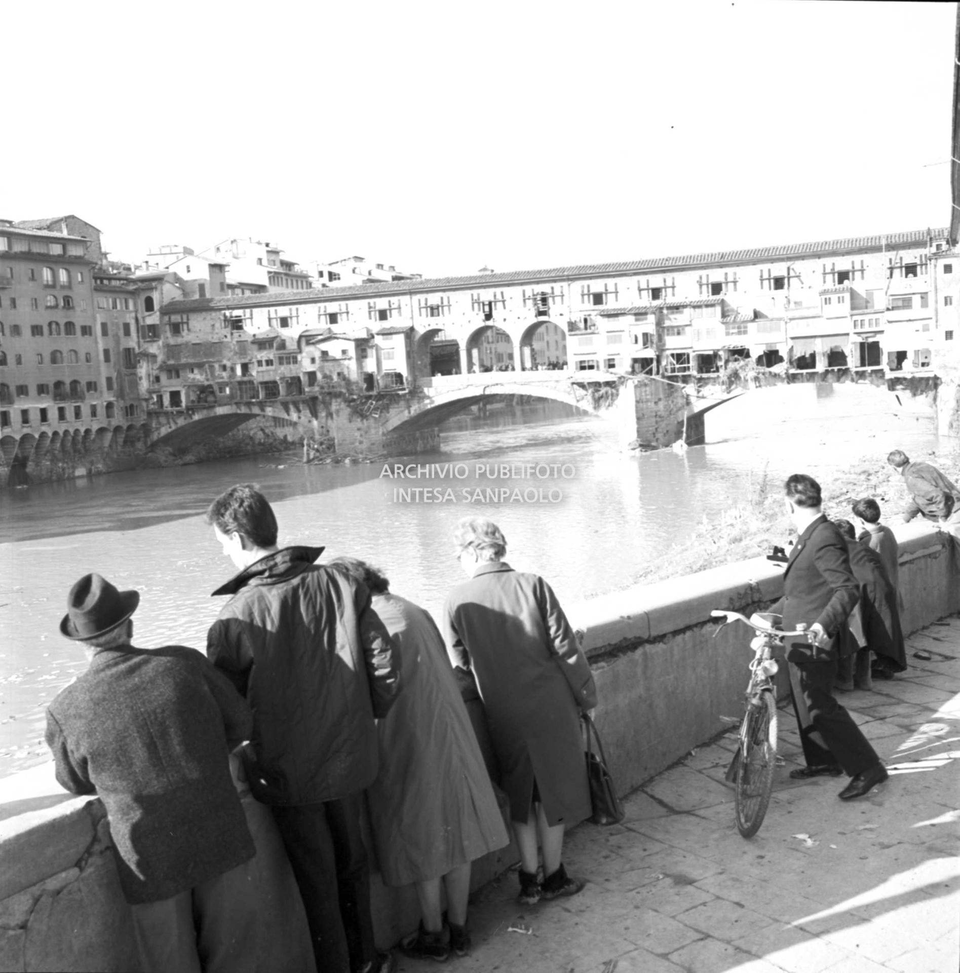 Alluvione di Firenze: passanti osservano il fiume Arno in prossimità del Ponte Vecchio danneggiato