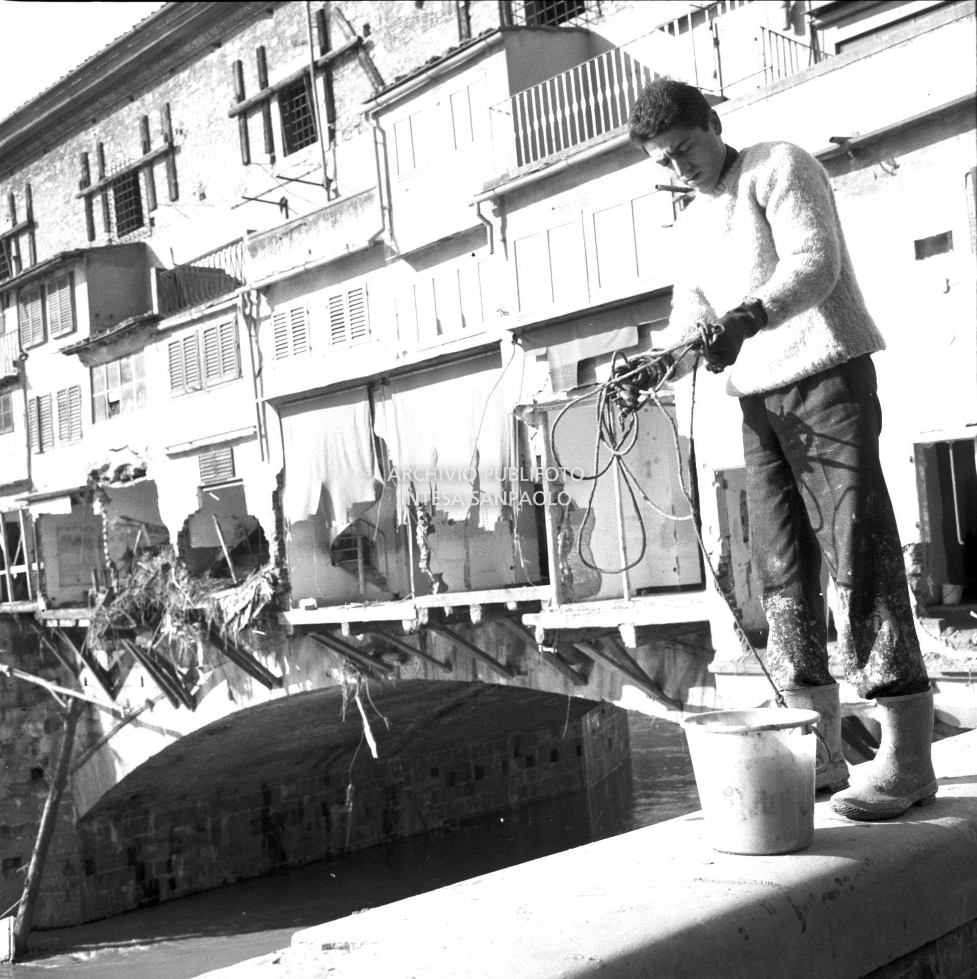 Alluvione di Firenze: un uomo al lavoro a ridosso del Ponte Vecchio danneggiato
