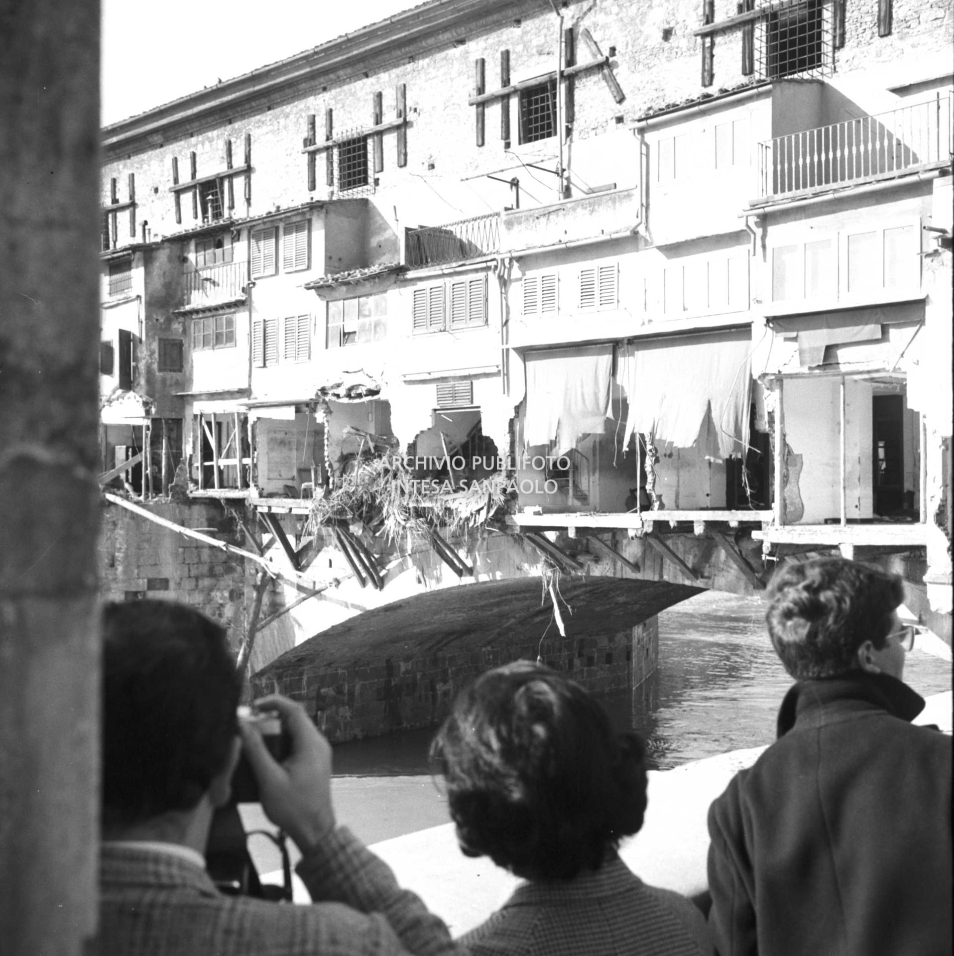 Alluvione di Firenze: passanti fotografano e osservano il Ponte Vecchio danneggiato