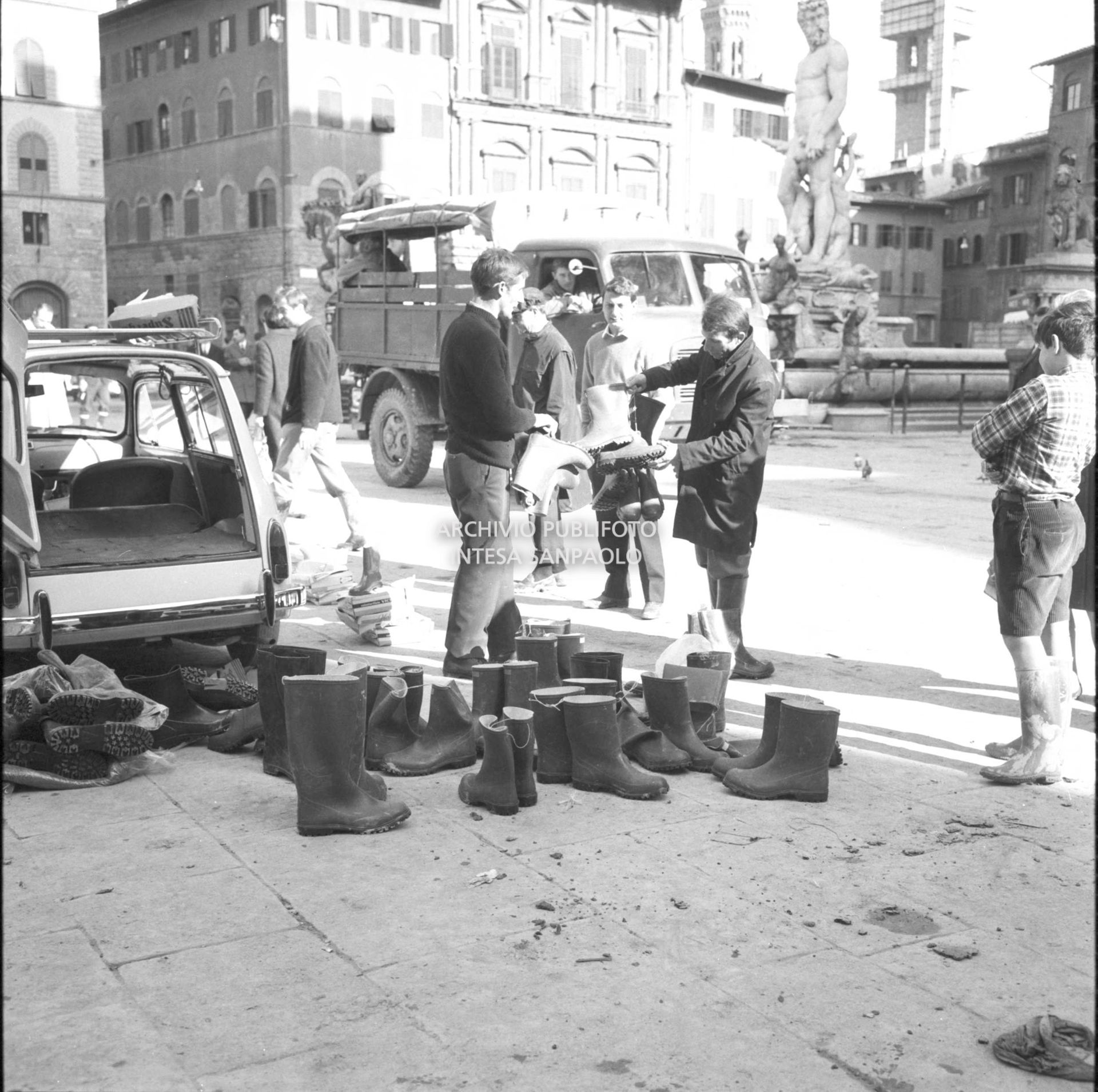 Alluvione di Firenze: vendita stivali di gomma in piazza della Signoria
