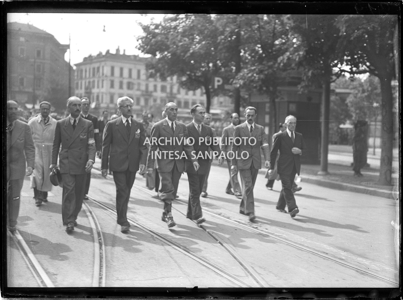 Mario Argenton, Giovan Battista Stucchi, Ferruccio Parri, il generale Raffaele Cadorna, Luigi Longo, Enrico Mattei e Fermo Solari sfilano a Milano, in piazza Castello, insieme alle formazioni partigiane