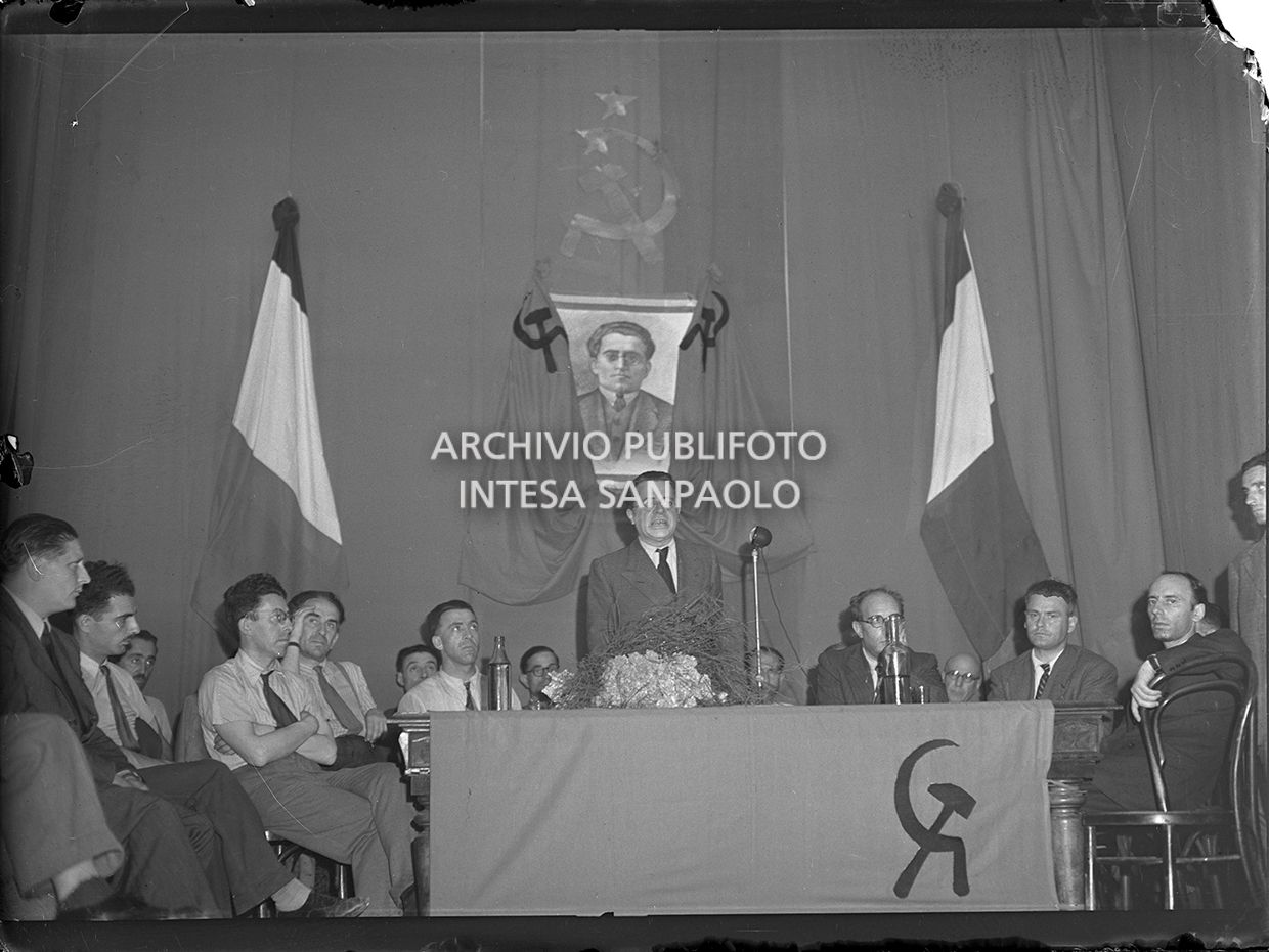 Palmiro Togliatti parla ai dirigenti comunisti riuniti presso la sede della Federazione Comunista a Milano a Porta Garibaldi. Alle sue spalle un ritratto di Antonio Gramsci