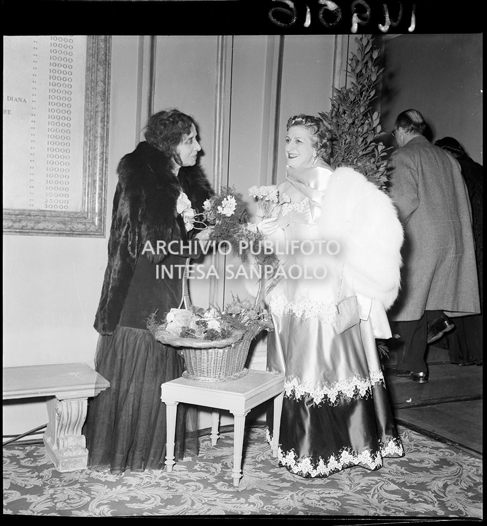 Tina Biffi con la fioraia del Teatro alla Scala in occasione della serata inaugurale della stagione lirica 1952-1953 con l'opera "Macbeth", di Giuseppe Verdi, diretta da Victor de Sabata, con la regia di Carl Ebert