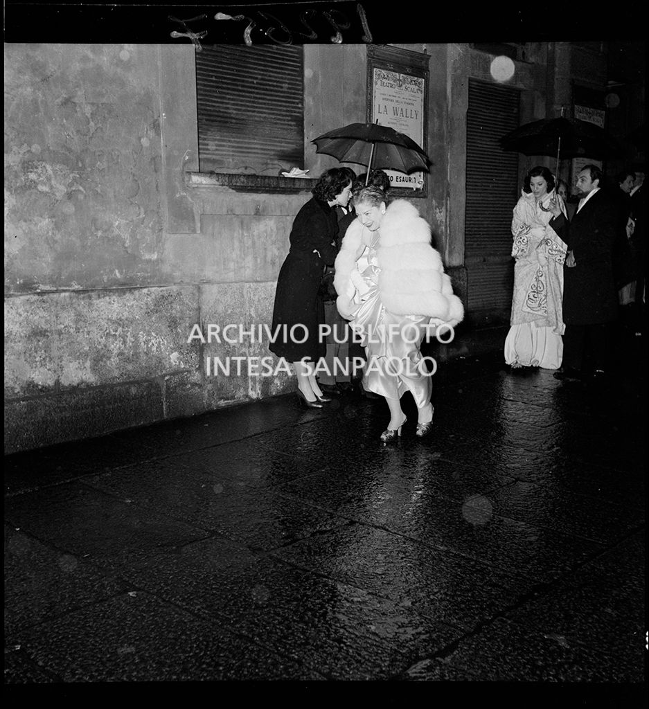 Spettatori all'esterno del Teatro alla Scala in occasione della serata inaugurale della stagione lirica 1953-1954 con l'opera "La Wally", di Alfredo Catalani, diretta da Carlo Maria Giulini, con la regia di Tatiana Pavlova