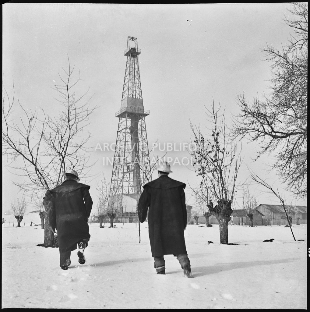 Operai presso un impianto Agip innevato<br>196012