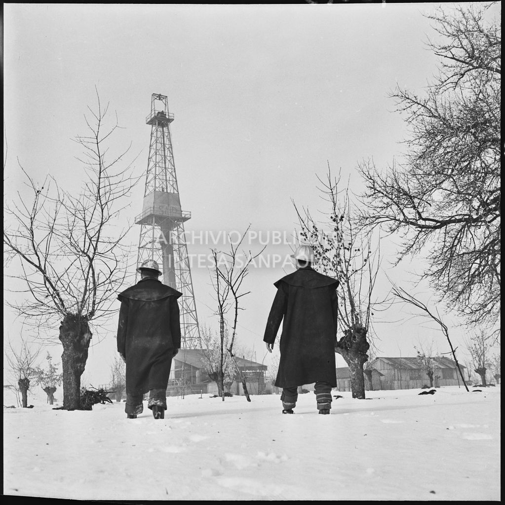 Operai presso un impianto Agip innevato<br>196013