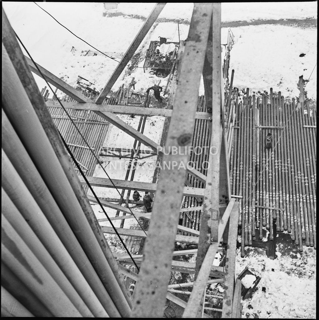 Operai al lavoro su un impianto Agip innevato<br>196014