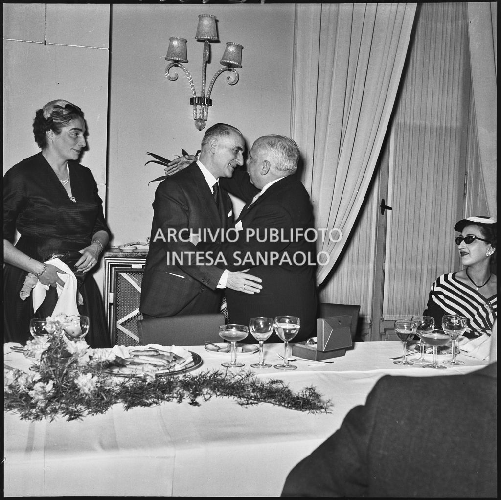Due uomini si abbracciano in occasione del banchetto della SAER al ristorante Tantalo di Milano<br>196129