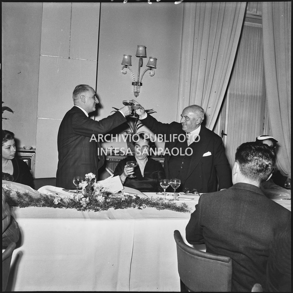 Due uomini brindano in occasione del banchetto della SAER al ristorante Tantalo di Milano<br>196133
