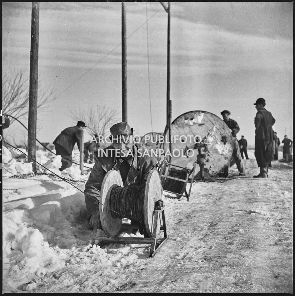 Operai al lavoro nella neve per l'allacciamento dei cavi elettrici della Edison<br>196140