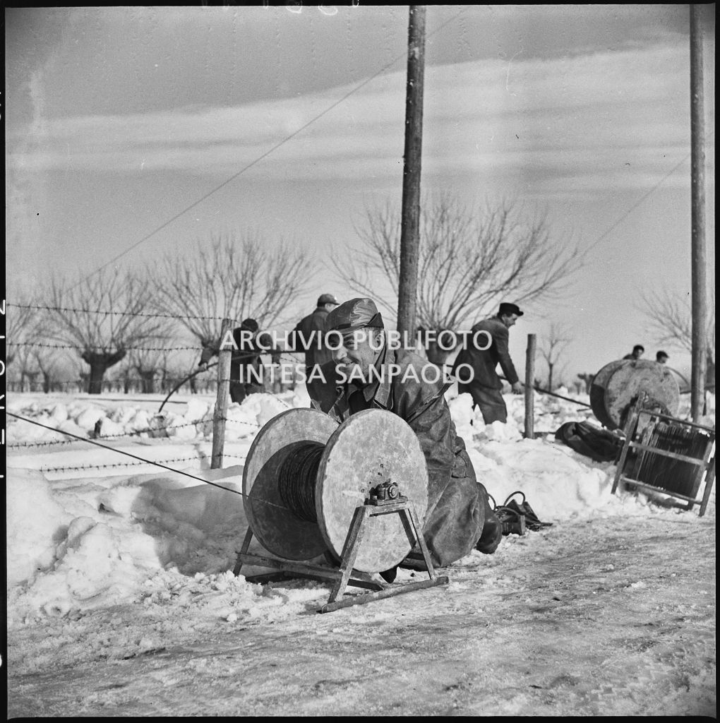 Operai al lavoro nella neve per l'allacciamento dei cavi elettrici della Edison<br>196141
