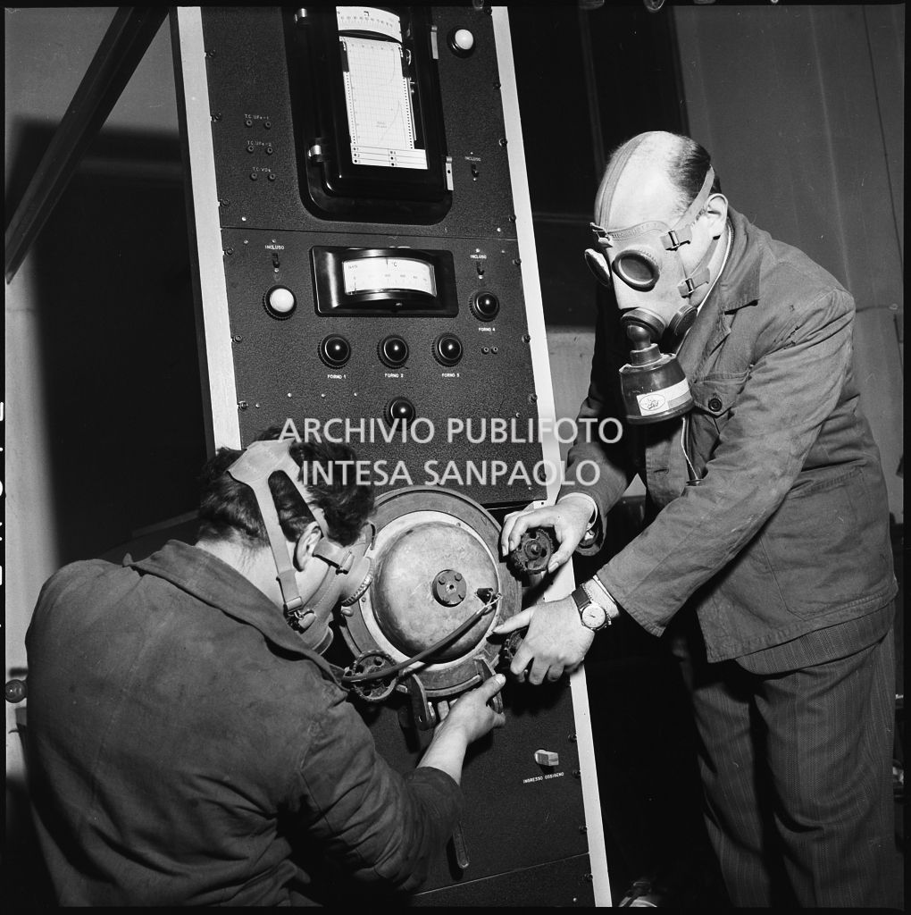 Due uomini con maschera anti gas al lavoro su un impianto del CISE<br>196214