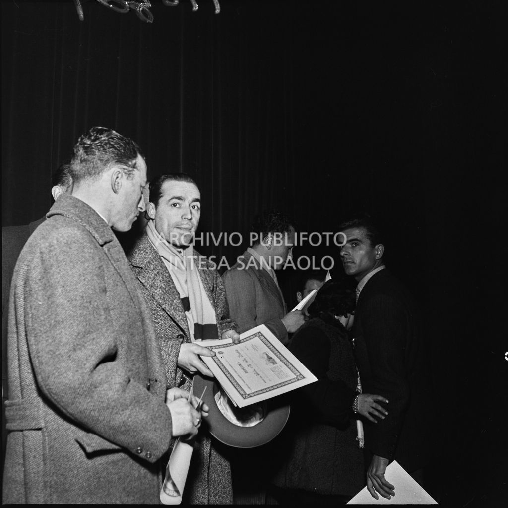 Uomini con in mano il premio ricevuto al congresso della Voce Comunista svoltosi al Teatro Lirico di Milano<br>196301