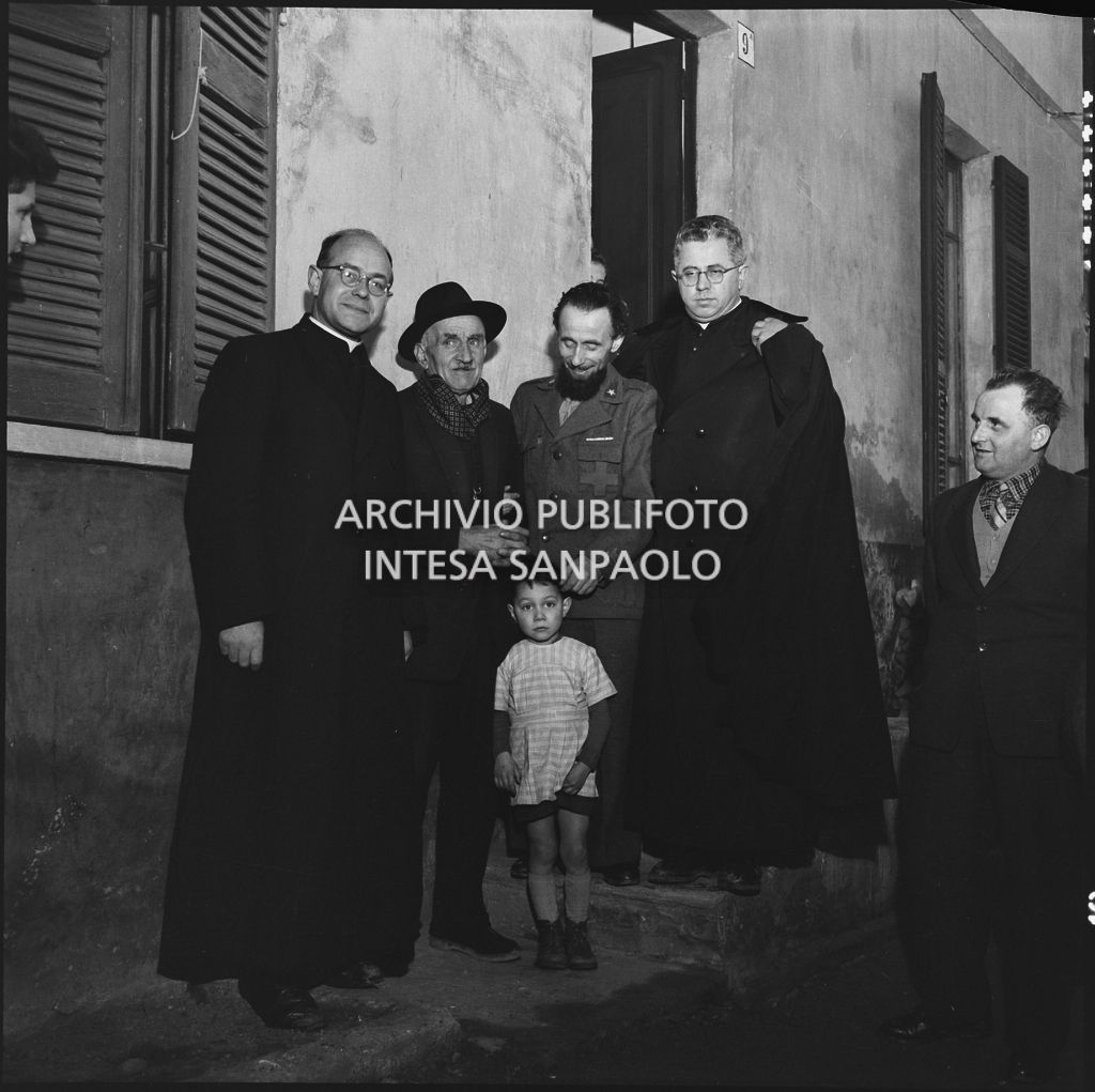 Padre Brevi di rientro in patria dopo la prigionia in Unione Sovietica circondato dalla famiglia e due sacerdoti<br>196373
