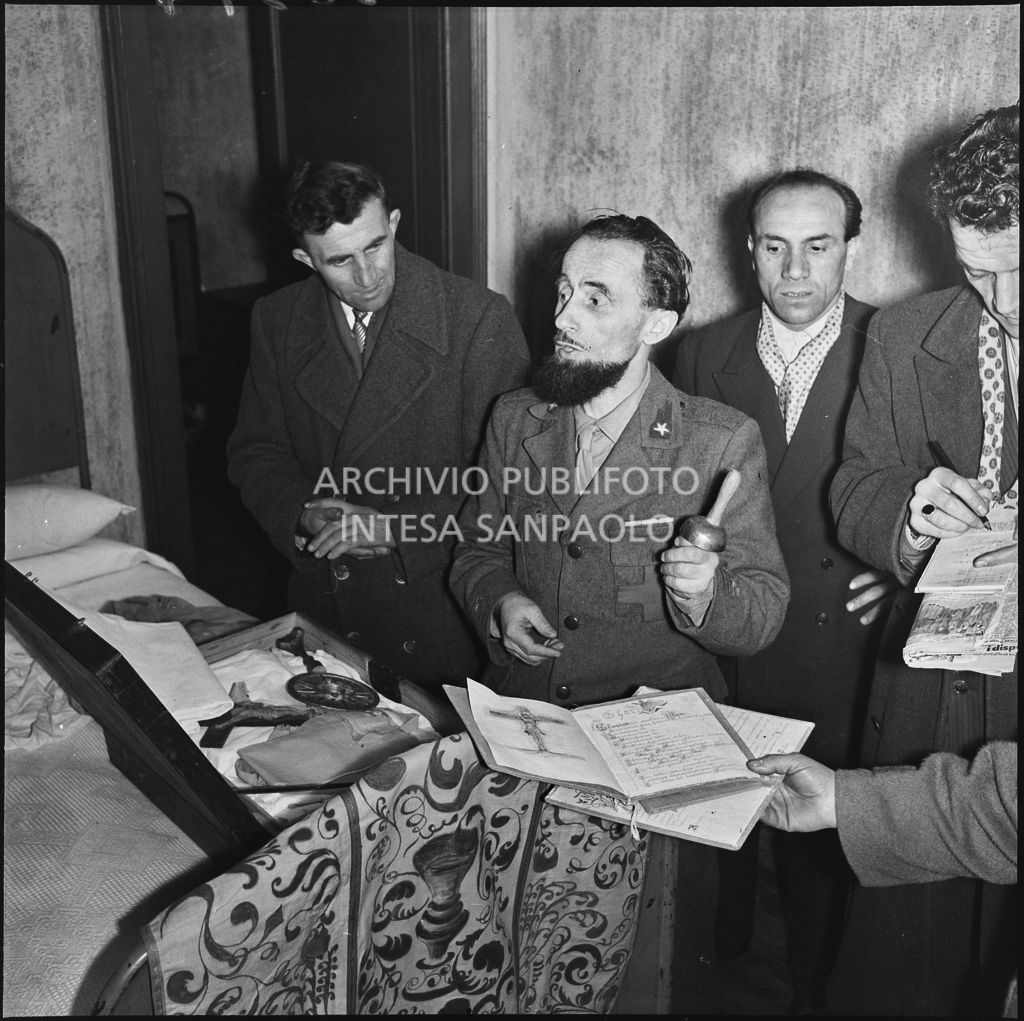 Padre Brevi, circondato da giornalisti, mostra alcuni oggetti religiosi al rientro in patria dopo la prigionia in Unione Sovietica<br>196377