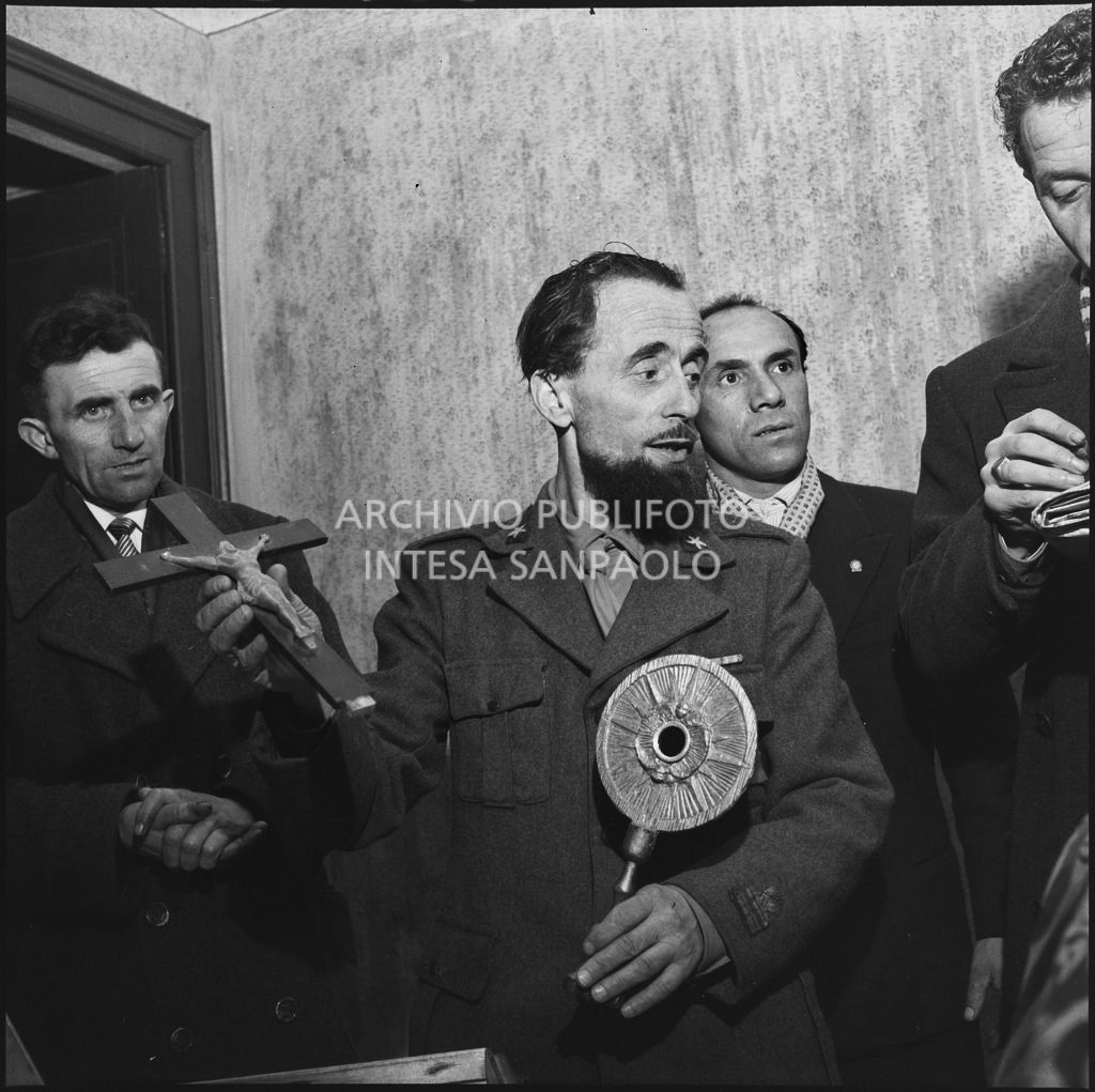 Padre Brevi, circondato da giornalisti, mostra alcuni oggetti religiosi al rientro in patria dopo la prigionia in Unione Sovietica<br>196382