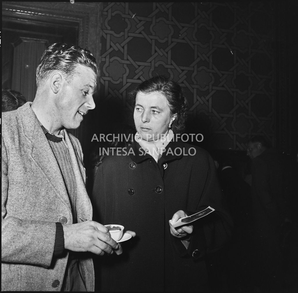 Ex prigioniero italiano osserva una fotografia mostratagli da una donna<br>196394