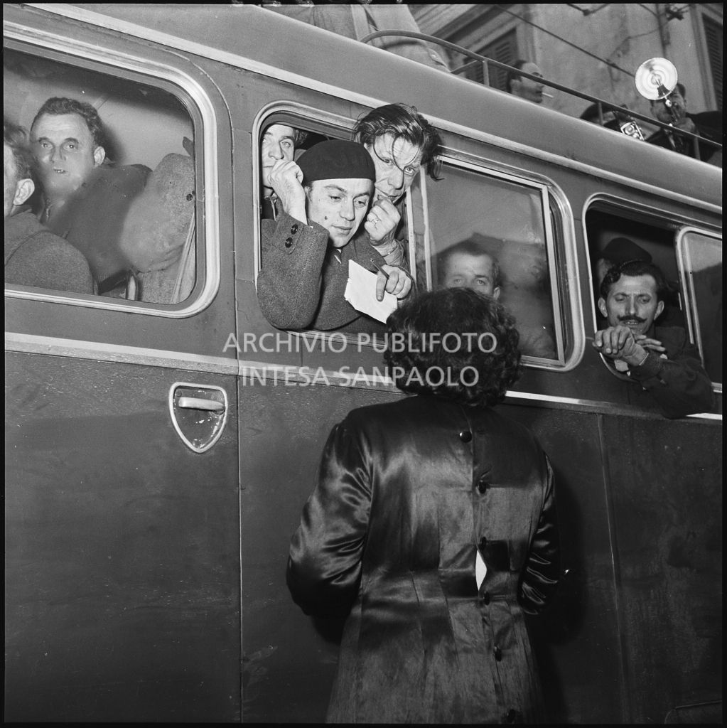 L'arrivo su un autobus di alcuni ex prigionieri italiani, tra cui Francesco Guglielmoni con in mano carta e penna<br>196395