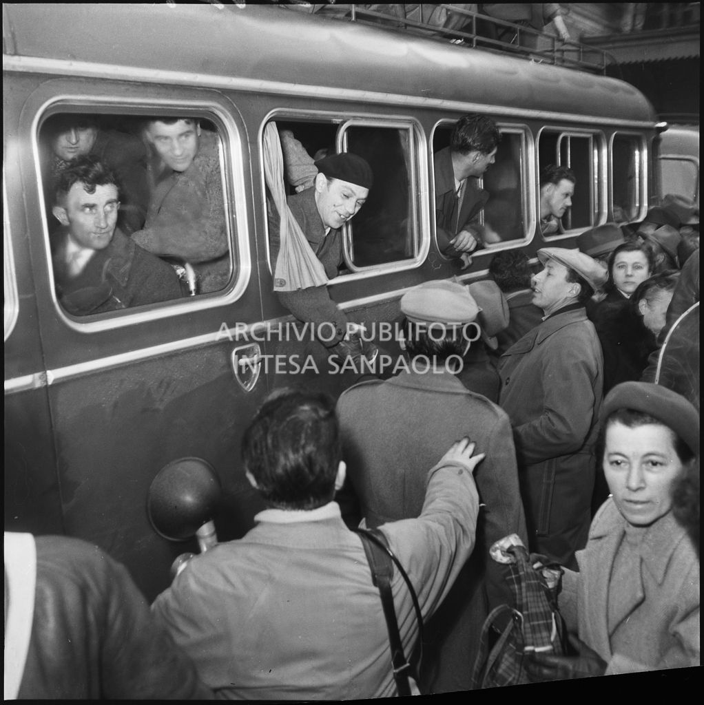 L'arrivo su un autobus di alcuni ex prigionieri italiani di ritorno dall'Unione Sovietica. Francesco Guglielmoni si sporge per stringere la mano ad un uomo<br>196397